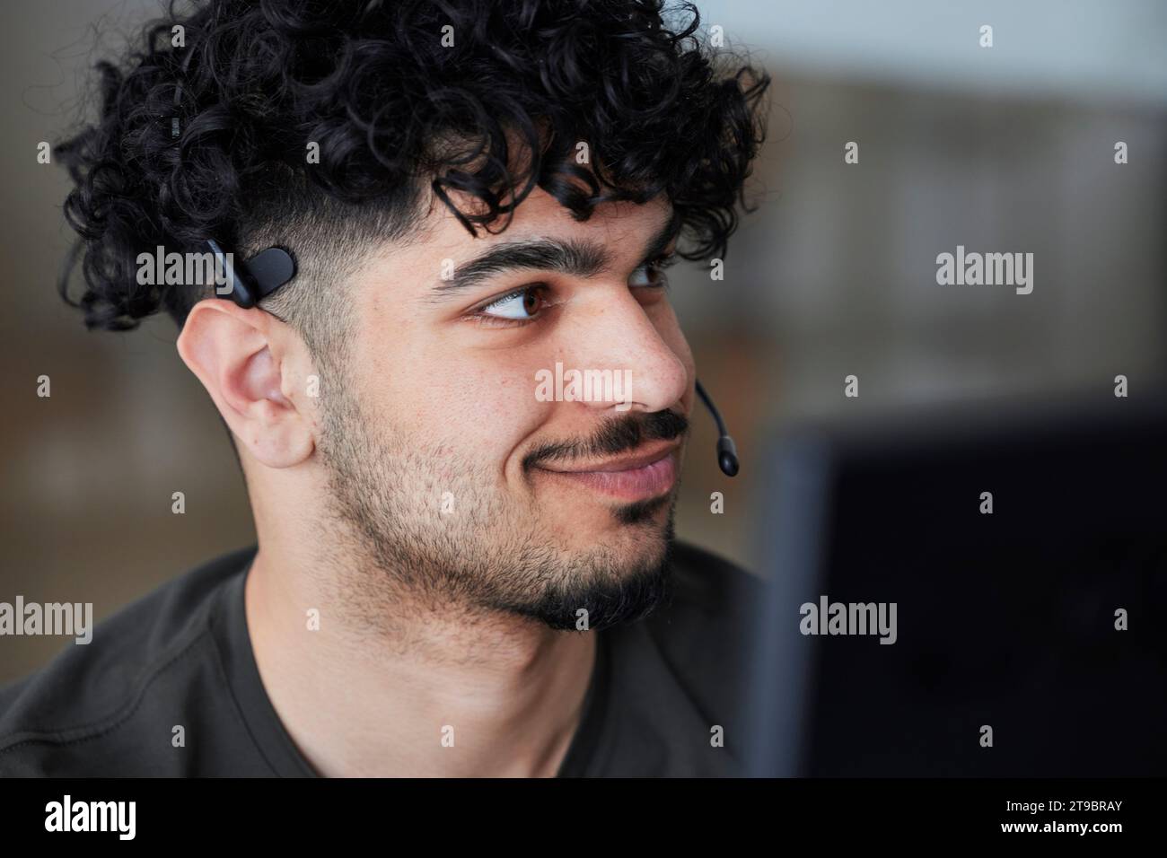 Smiling man wearing headset looking away Stock Photo
