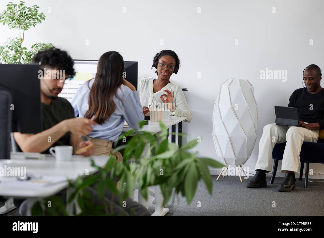 People sitting and using computers in office Stock Photo