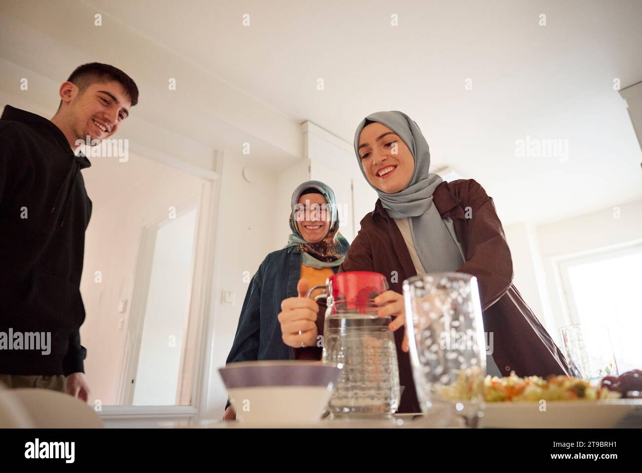 Family setting table for eid al-fitr together at home Stock Photo - Alamy