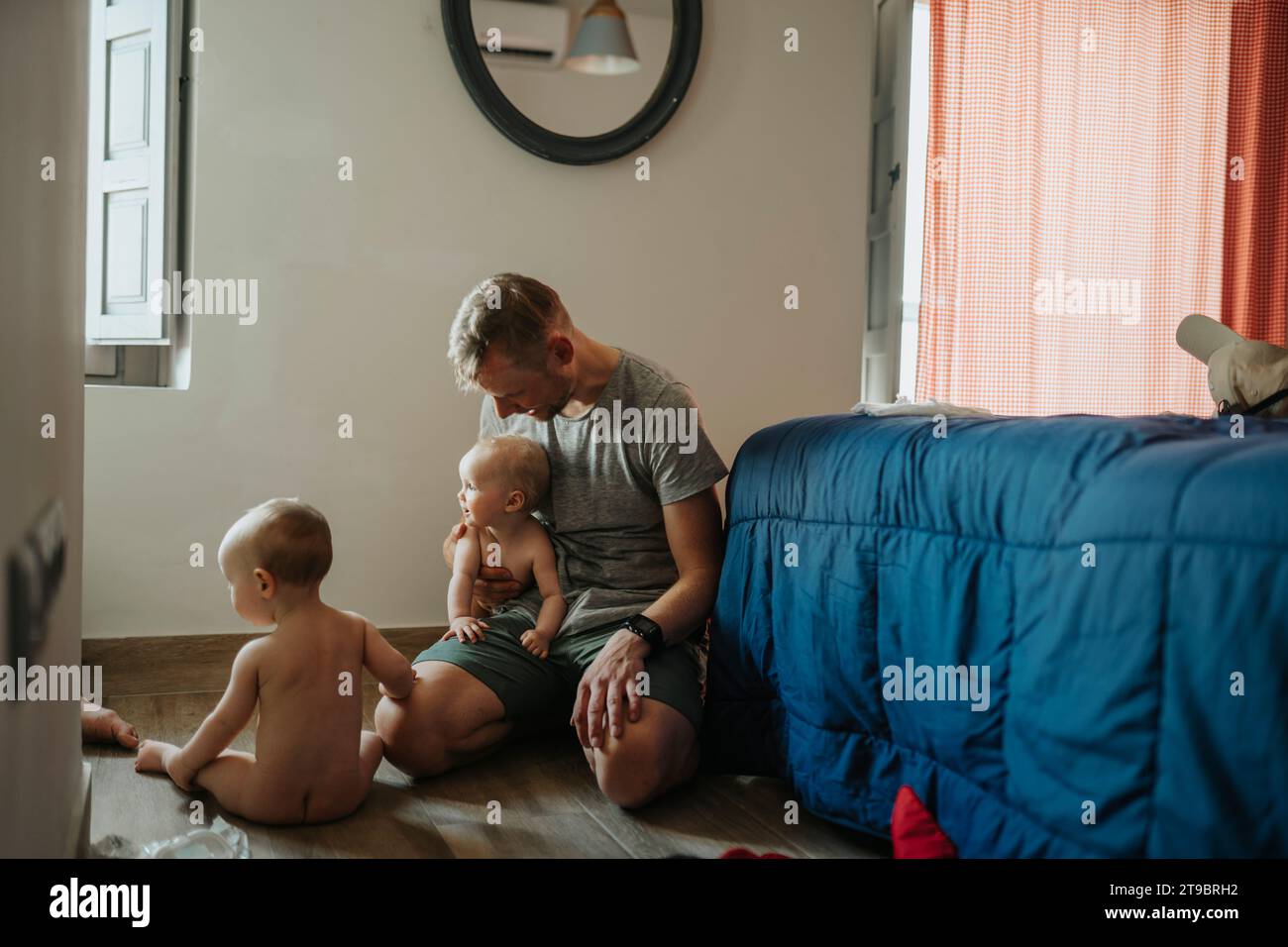 Father taking care of babies at home Stock Photo