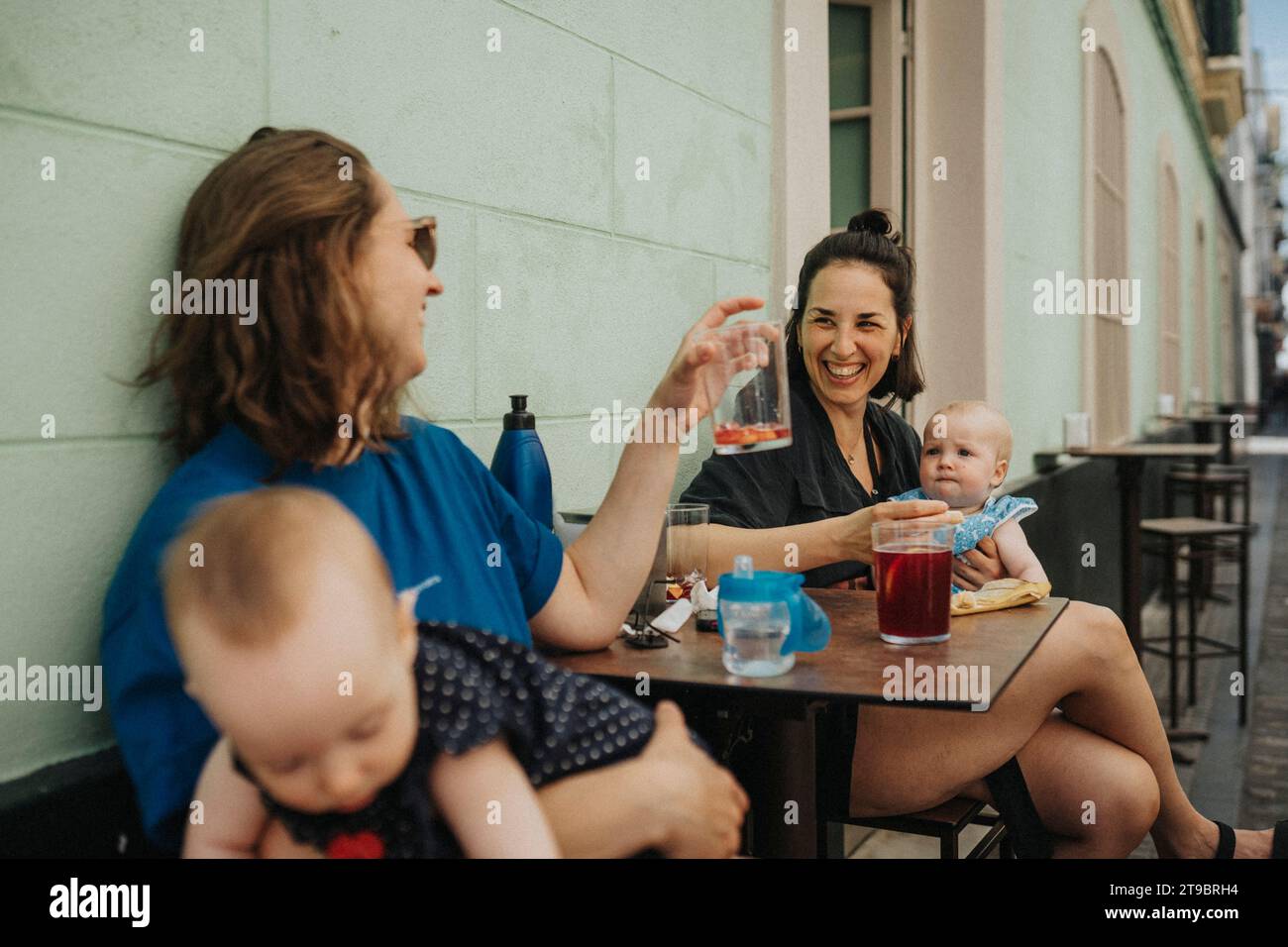 Mothers with babies relaxing in sidewalk cafe Stock Photo