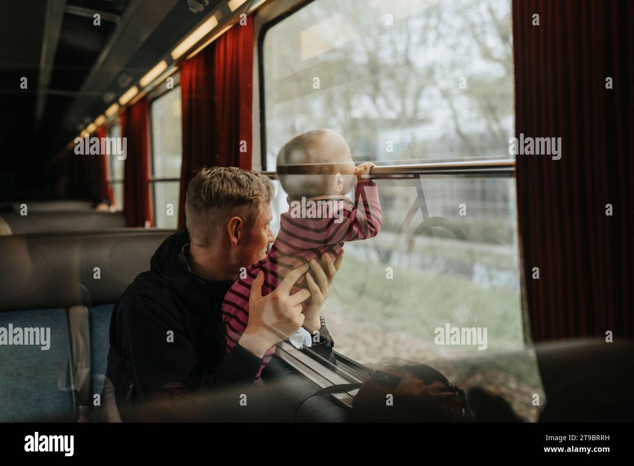 Father traveling with baby by train Stock Photo