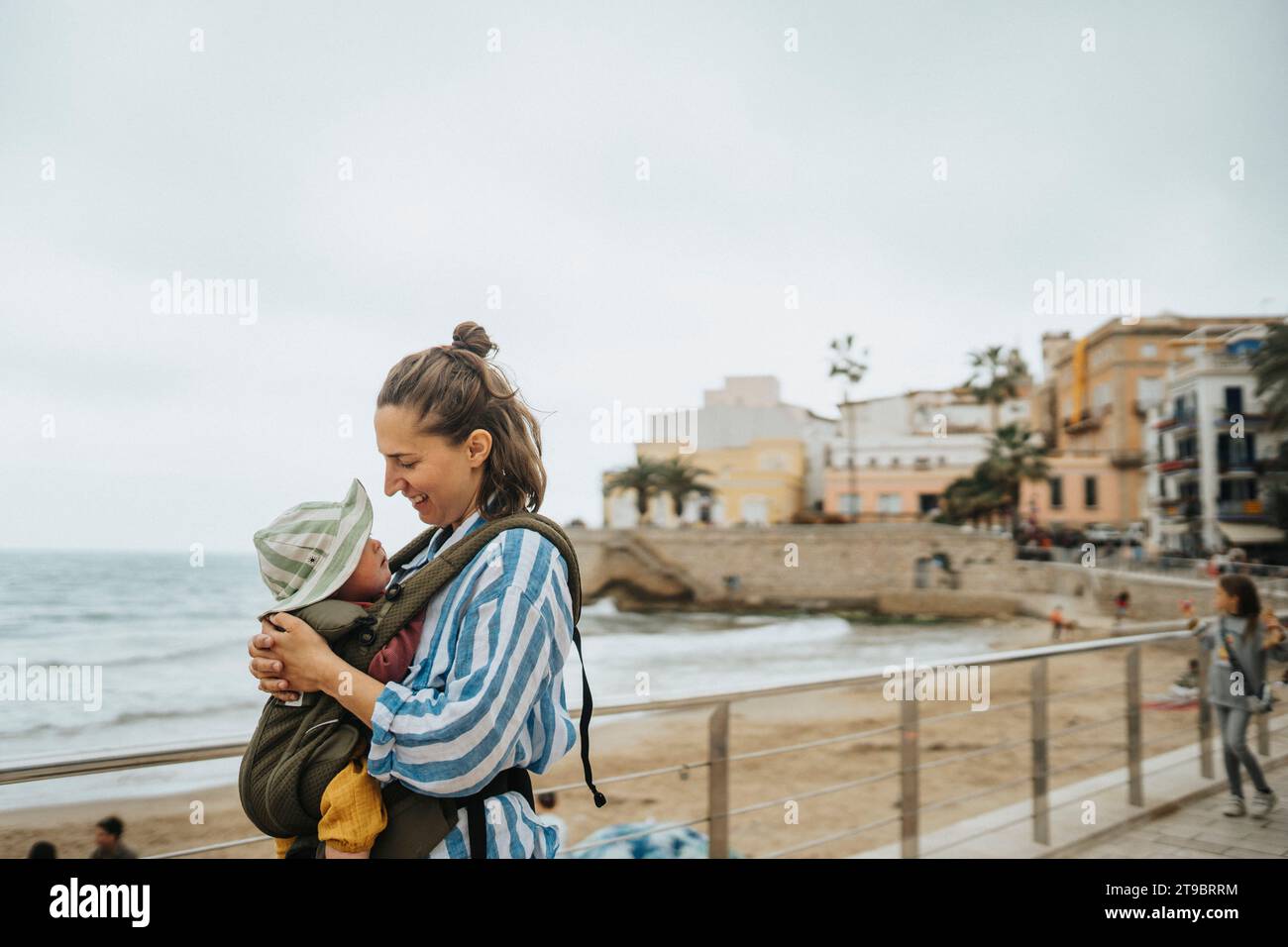 Mother with baby relaxing on beach Stock Photo