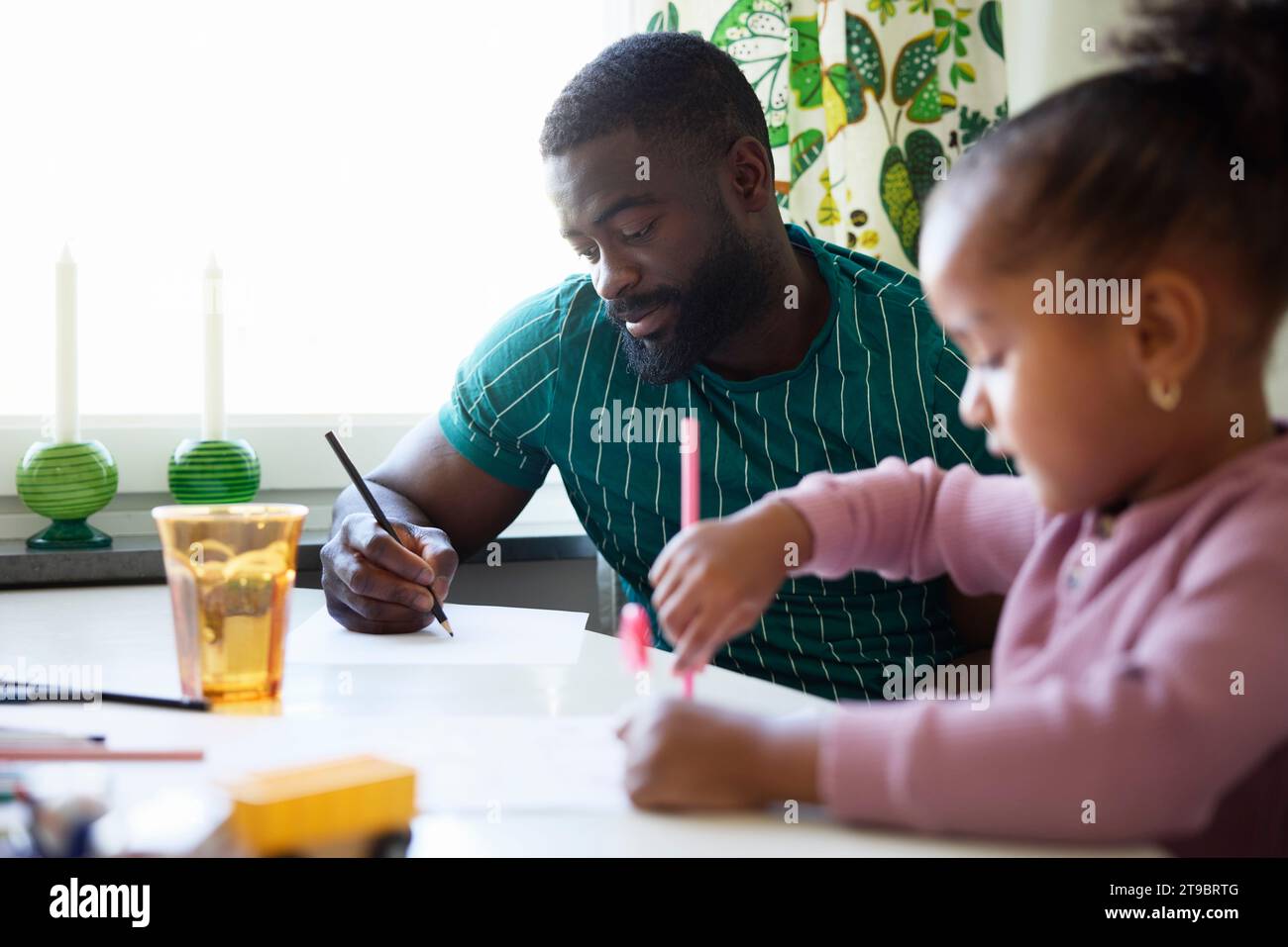 Father and daughter drawing together at  home Stock Photo