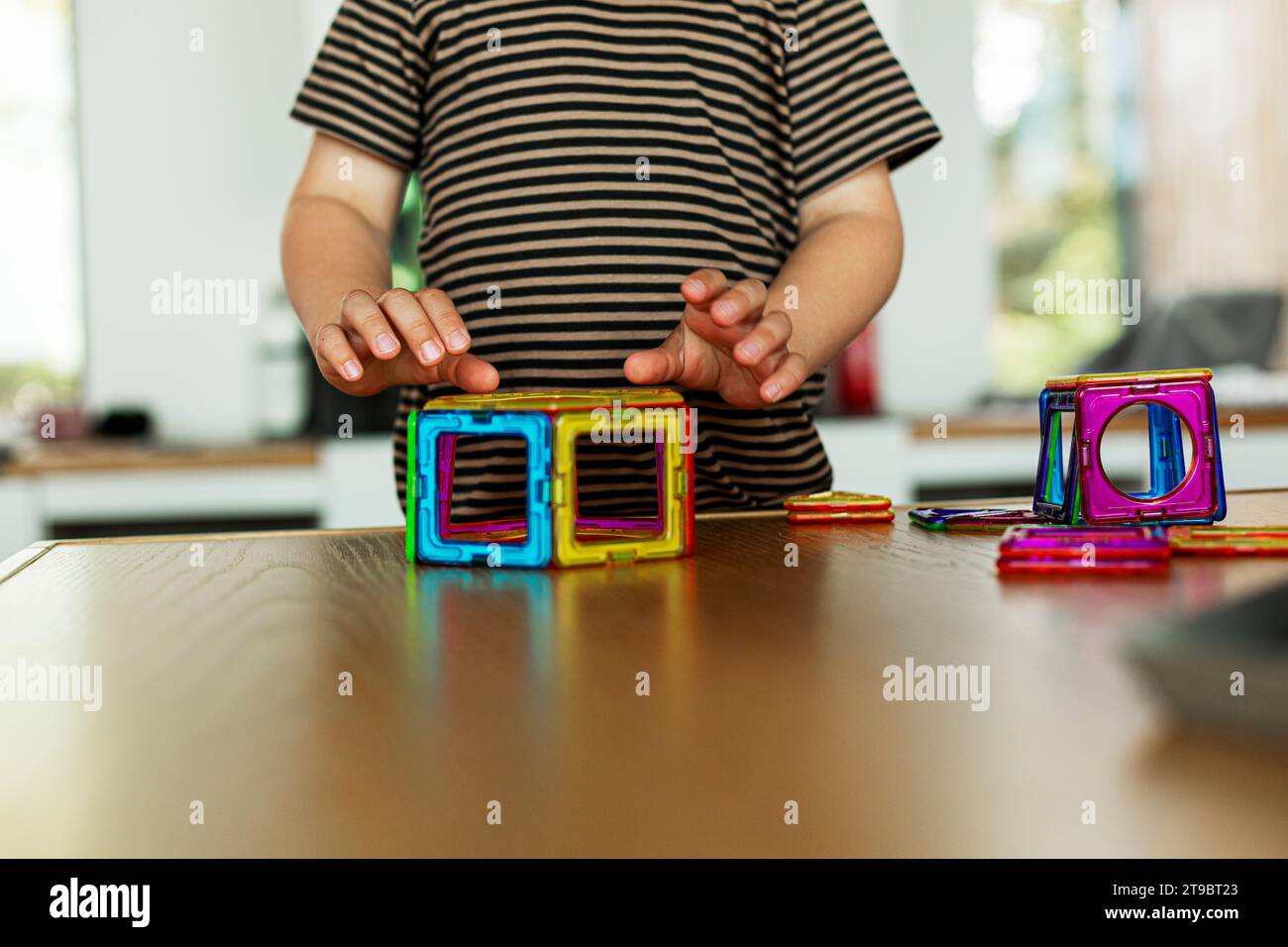 Midsection of boy playing with toy block on table at home Stock Photo