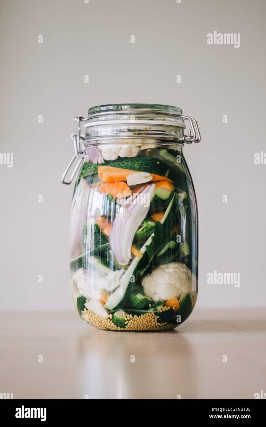 Healthy salad with veggies and quinoa in jar on table Stock Photo