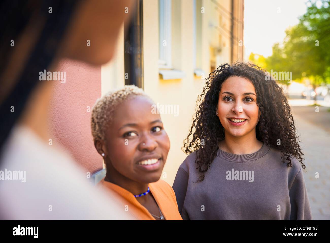 Smiling multiracial female friends talking with each other Stock Photo