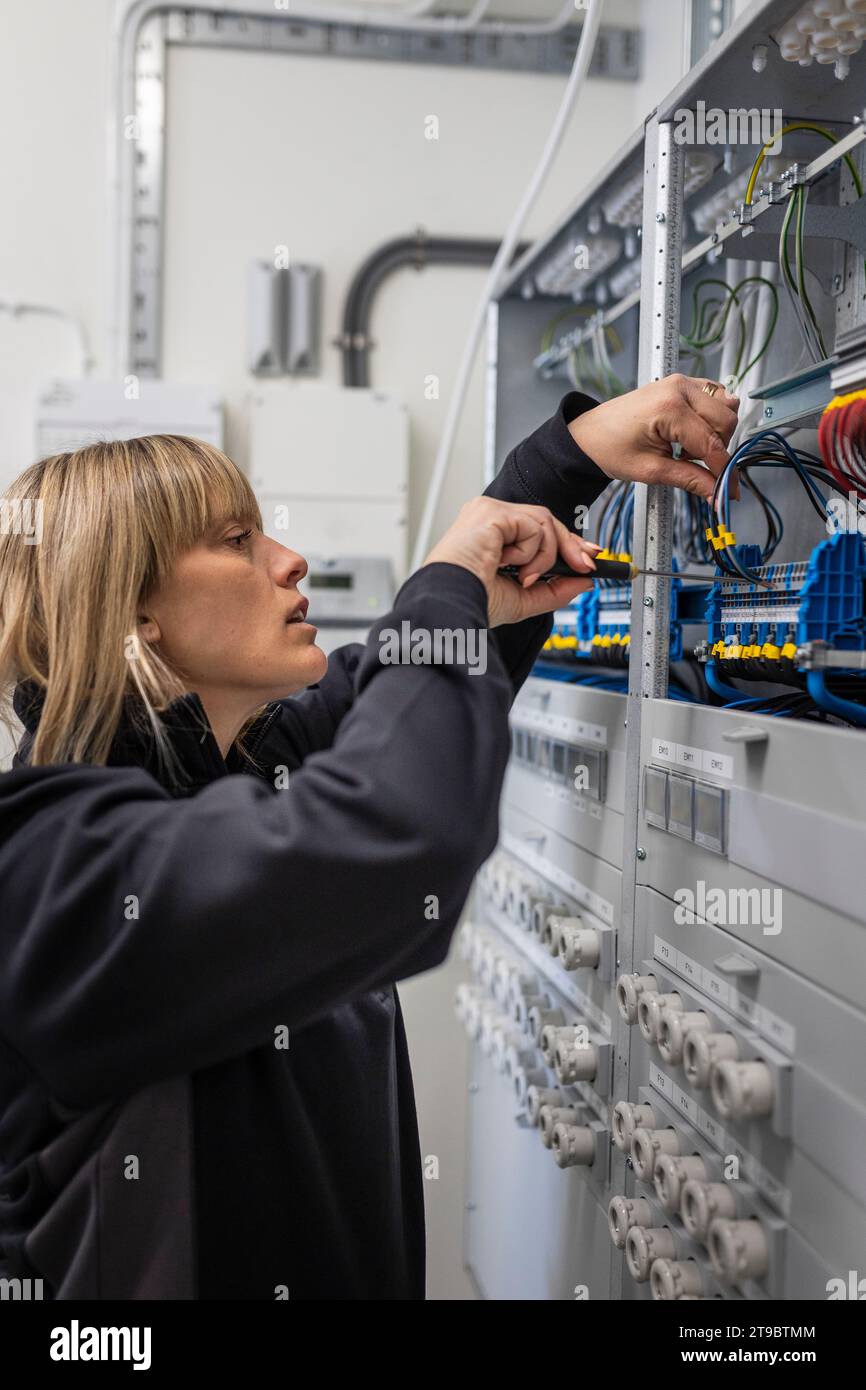 Female technician checking cables in control room at industry Stock Photo