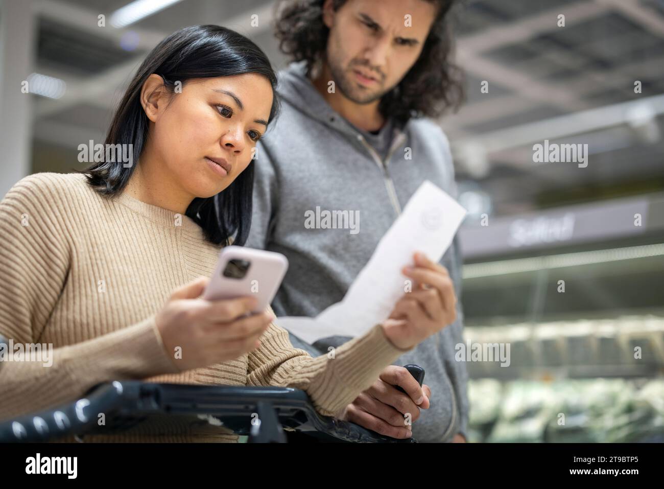 Young couple discussing over receipt at supermarket Stock Photo