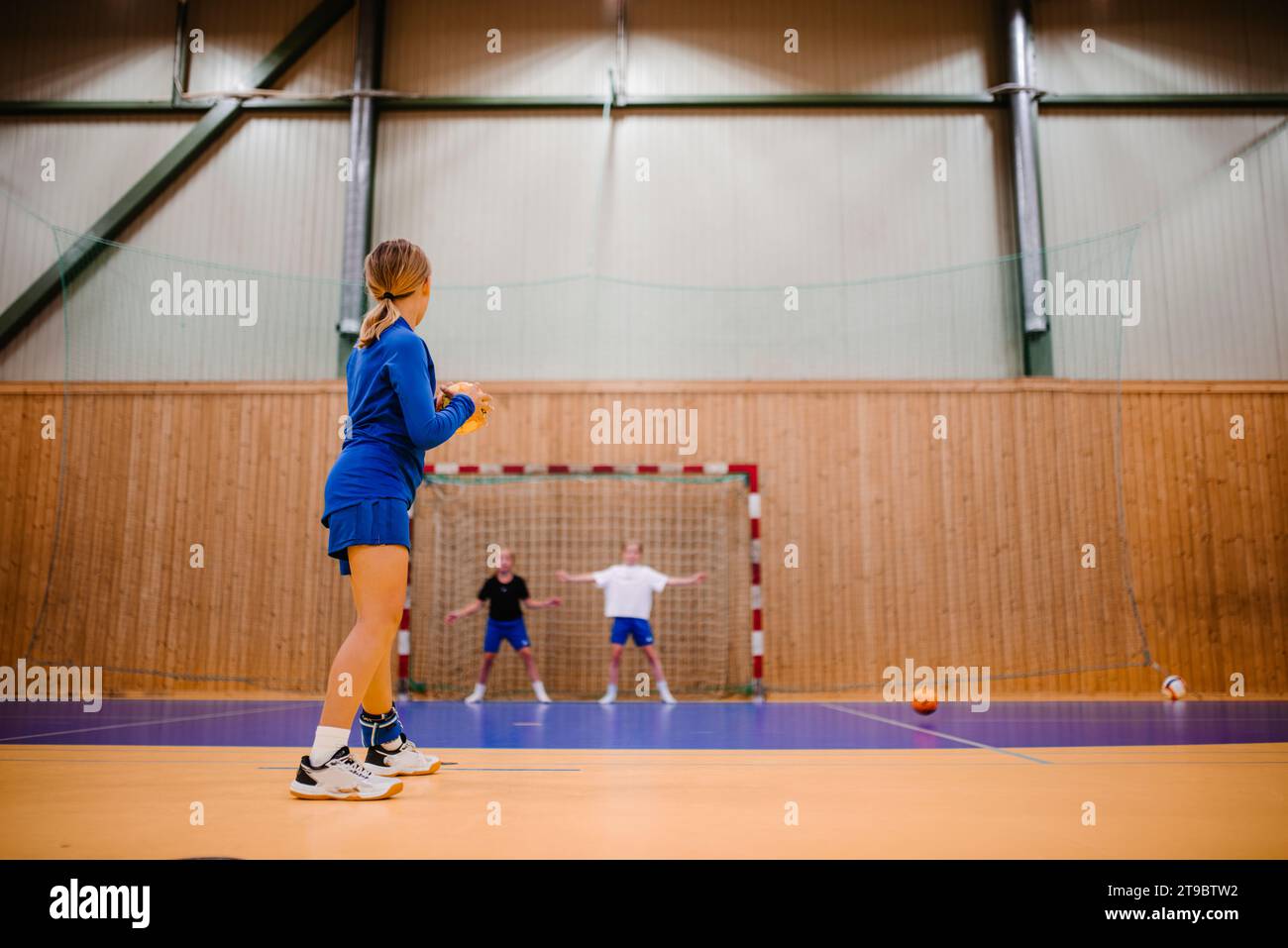Side view of female handball player preparing to throw ball in sports
