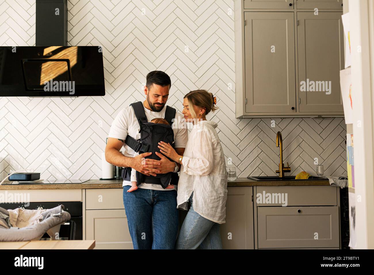 Father and mother with son in kitchen at home Stock Photo