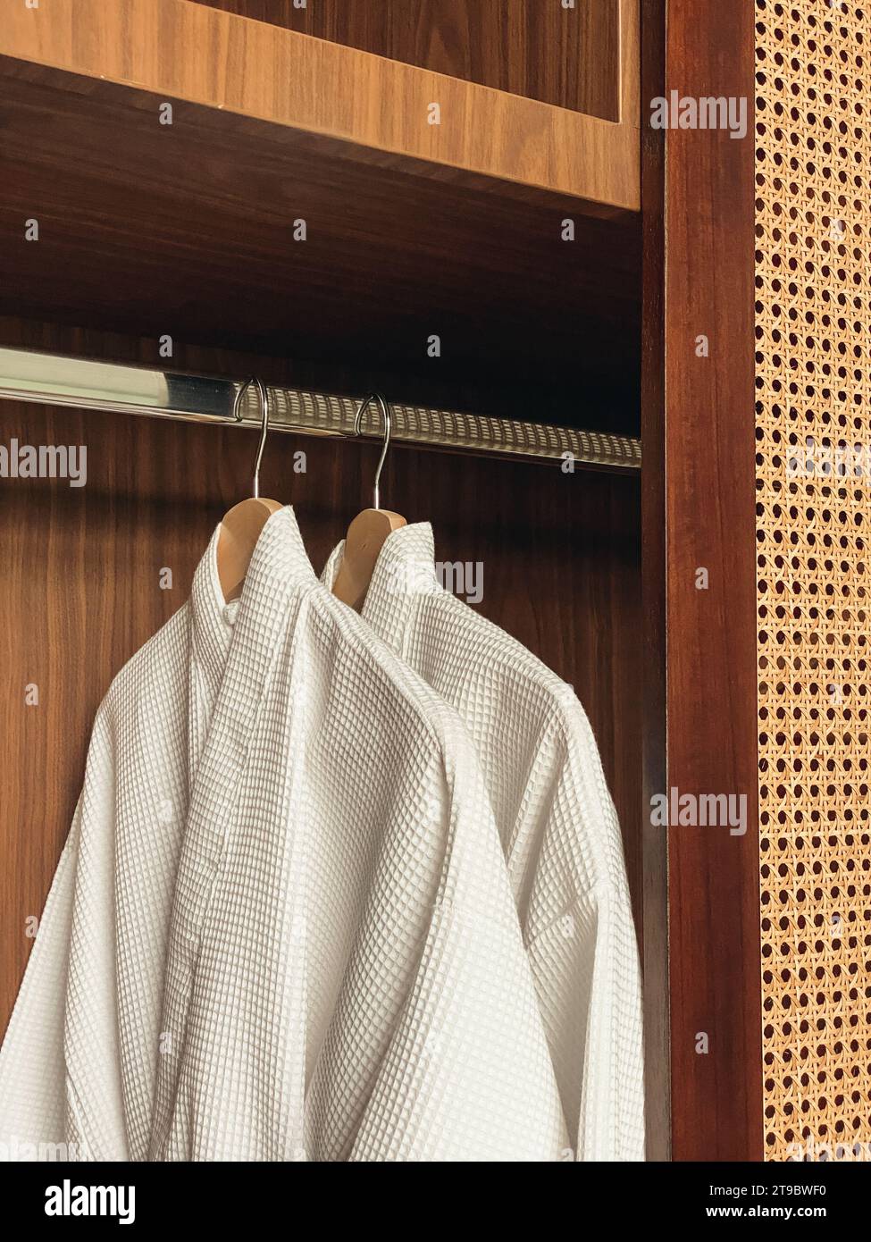 https://c8.alamy.com/comp/2T9BWF0/two-white-clean-bathrobes-hanging-in-wooden-wardrobe-at-luxury-hotel-or-home-relax-and-travel-concept-2T9BWF0.jpg