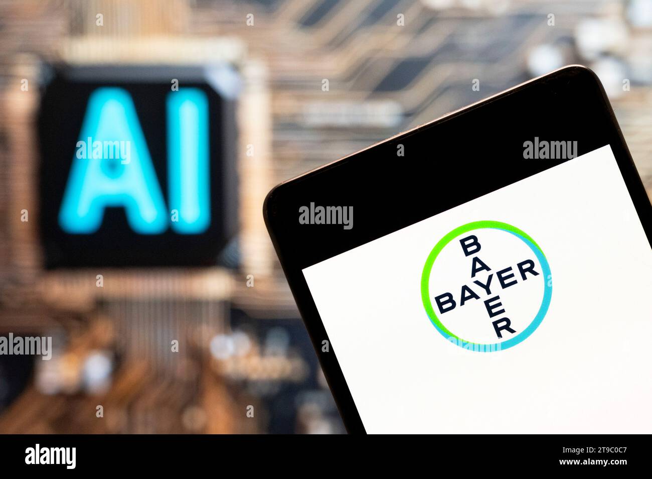 In this photo illustration, the German multinational pharmaceutical company, the Bayer AG (ETR: BAYN) logo seen displayed on a smartphone with an Artificial intelligence (AI) chip and symbol in the background. (Photo by Budrul Chukrut / SOPA Images/Sipa USA) *** Strictly for editorial news purposes only *** Stock Photo