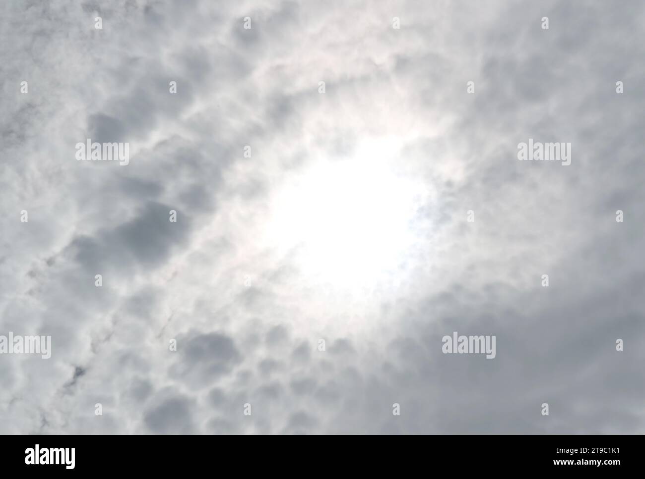Bright Sunbeam Shining Among Fluffy Altocumulus Clouds Stock Photo