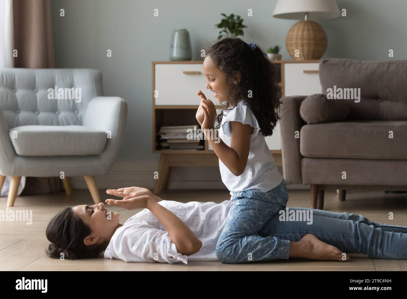 Little Indian girl play patty cake with young mother Stock Photo Alamy