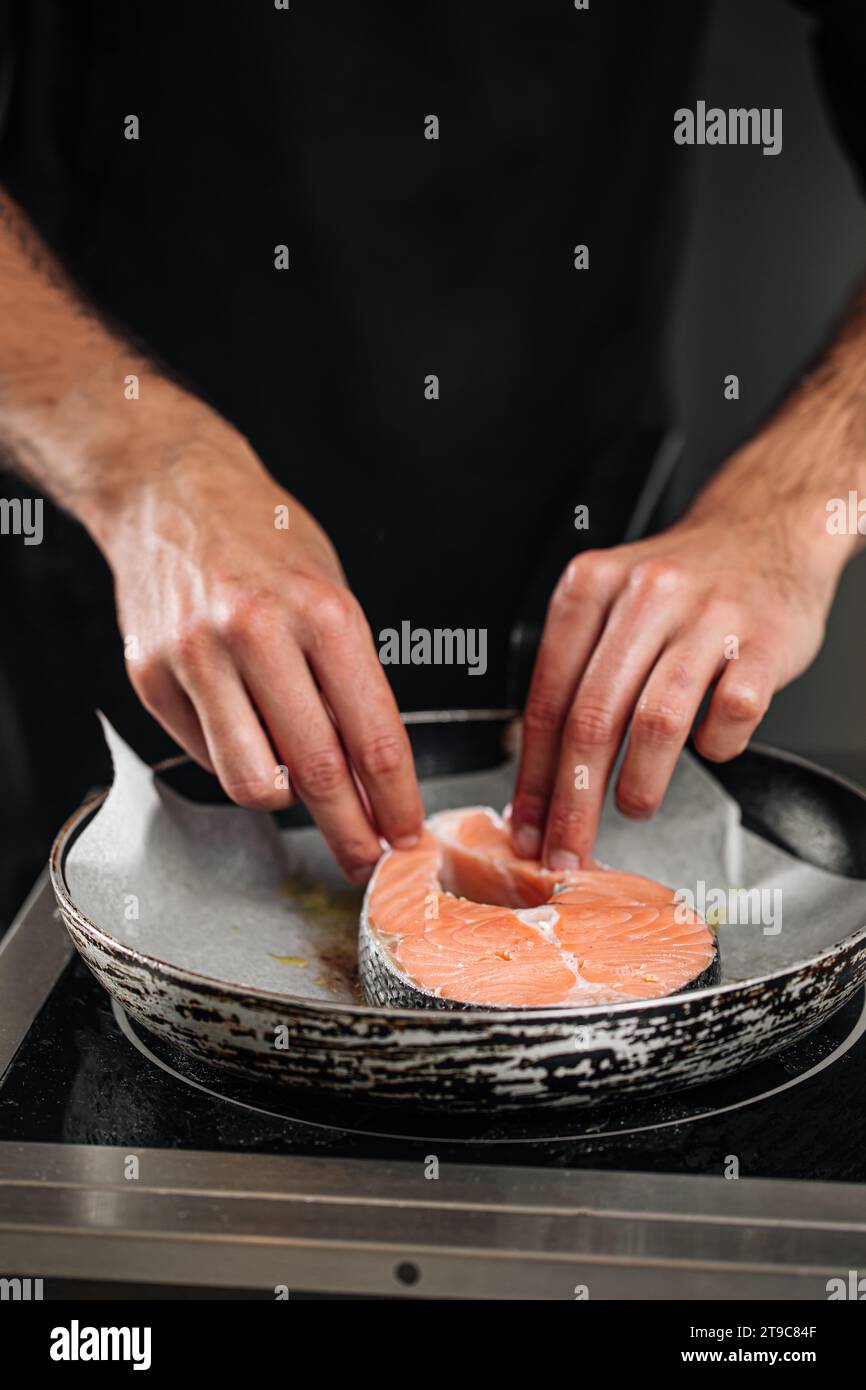 Man cooking salmon steak roasting on parchment Stock Photo