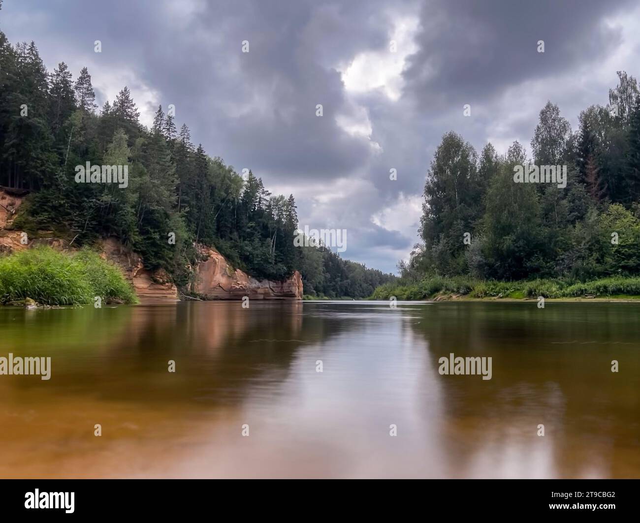 Nature's looking glass: A tranquil river gracefully winds its way through a serene forest, its mirror-like surface reflecting the lush beauty of the s Stock Photo