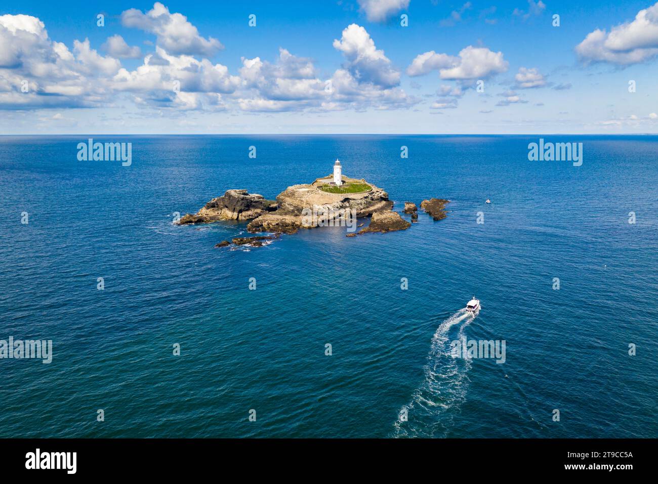 Aerial view of boat approaching Godrevy lighthouse and island, St Ives Bay, Cornwall, England. Spring (May) 2021. Stock Photo