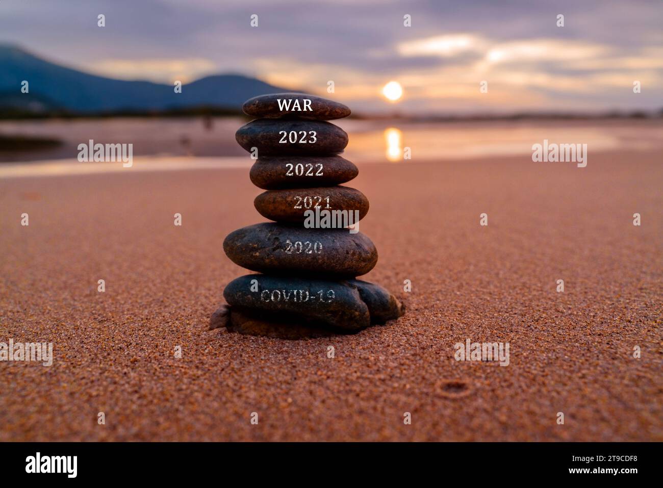 Happy new year 2024 is coming with great concept and design. Stone tower stacked on the beach Stock Photo
