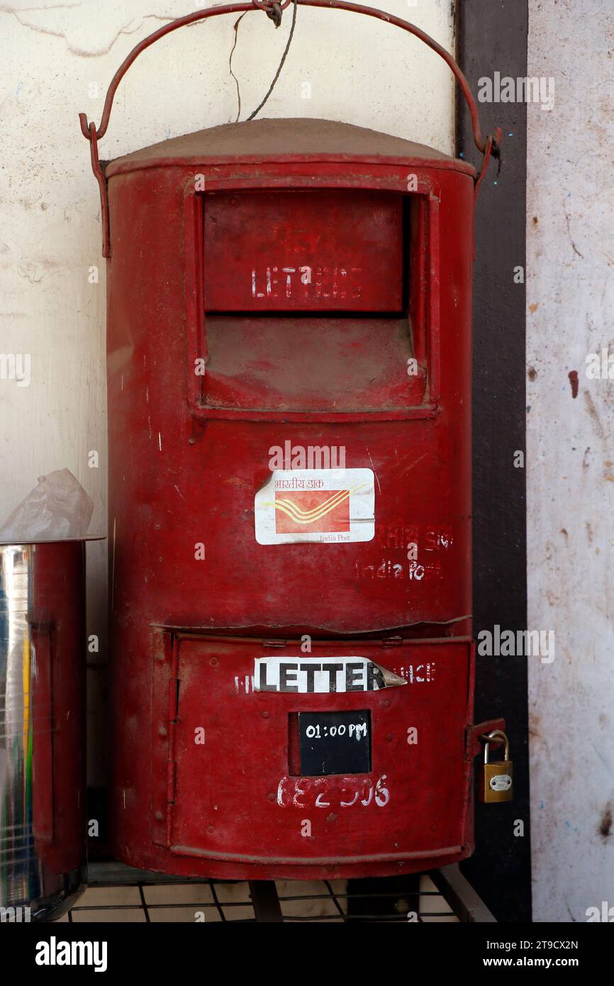 An old Indian red  post box hanging on a wall in kerala Stock Photo