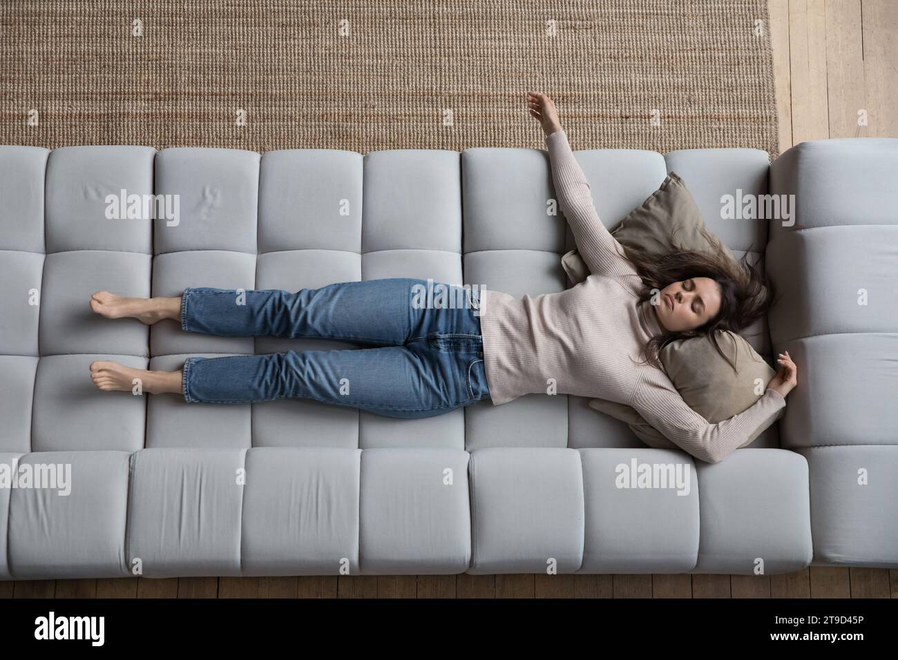 Young exhausted woman sleeping on sofa, above view Stock Photo