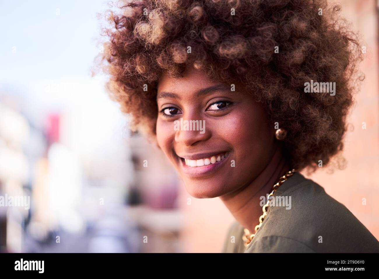 Cheerful portrait of an African young woman looking at camera smiling. Stock Photo