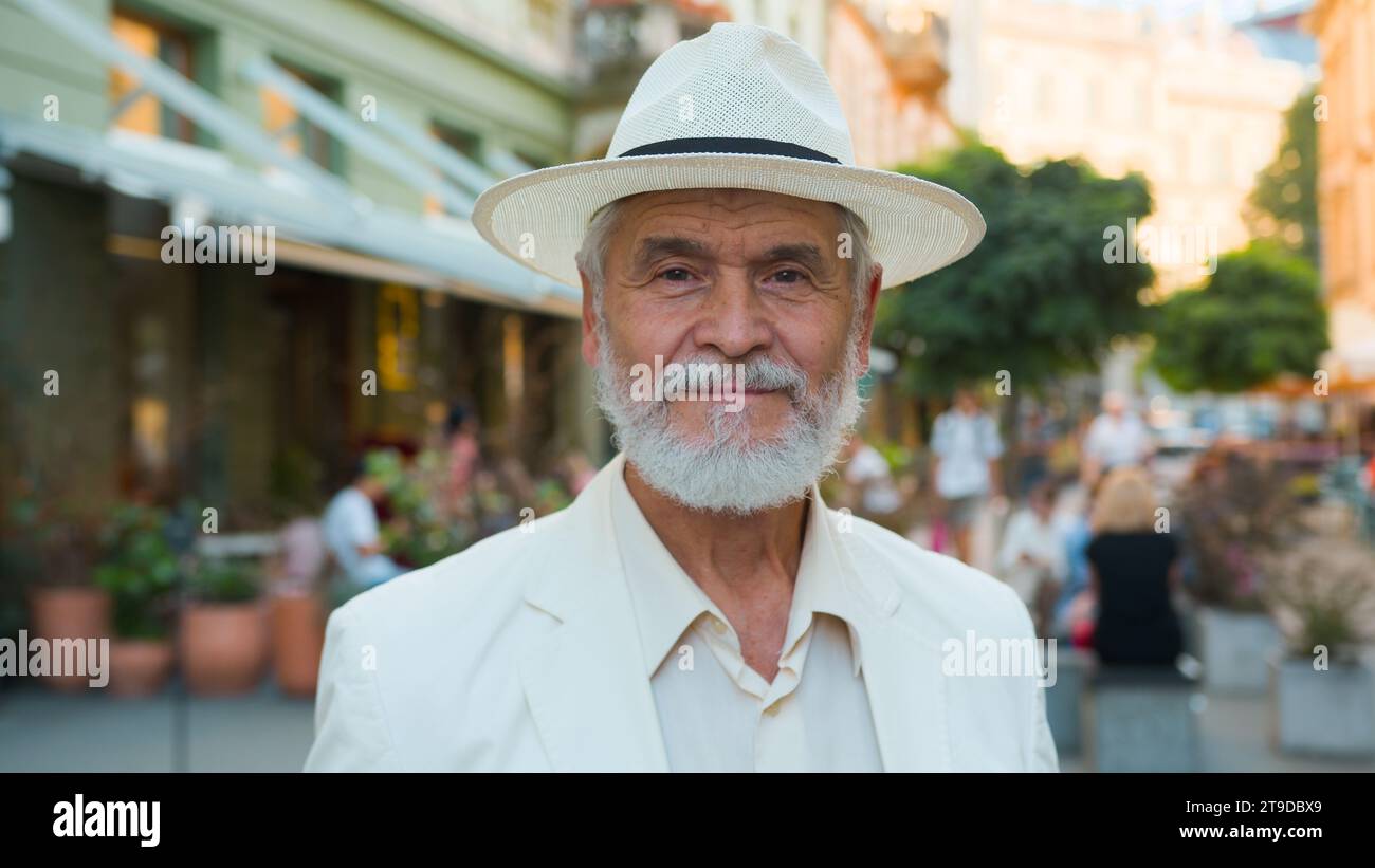Close up calm old senior 60s elderly mature gray-haired Caucasian elegant man retired businessman intelligent male tourist looking camera outside city Stock Photo