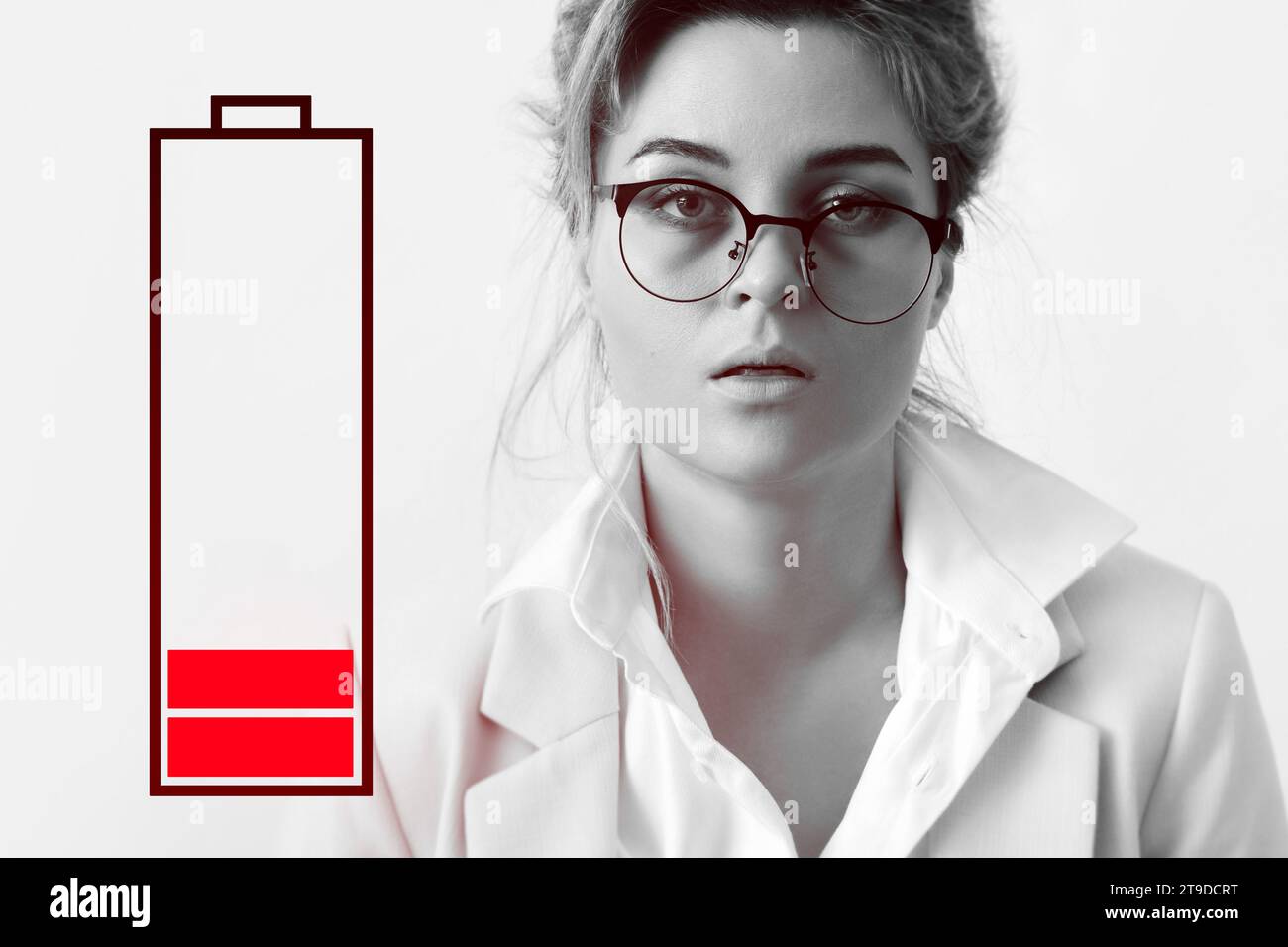 Very tired businesswoman and low battery symbol. Concepts of job burnout, overwork and stress. Stock Photo