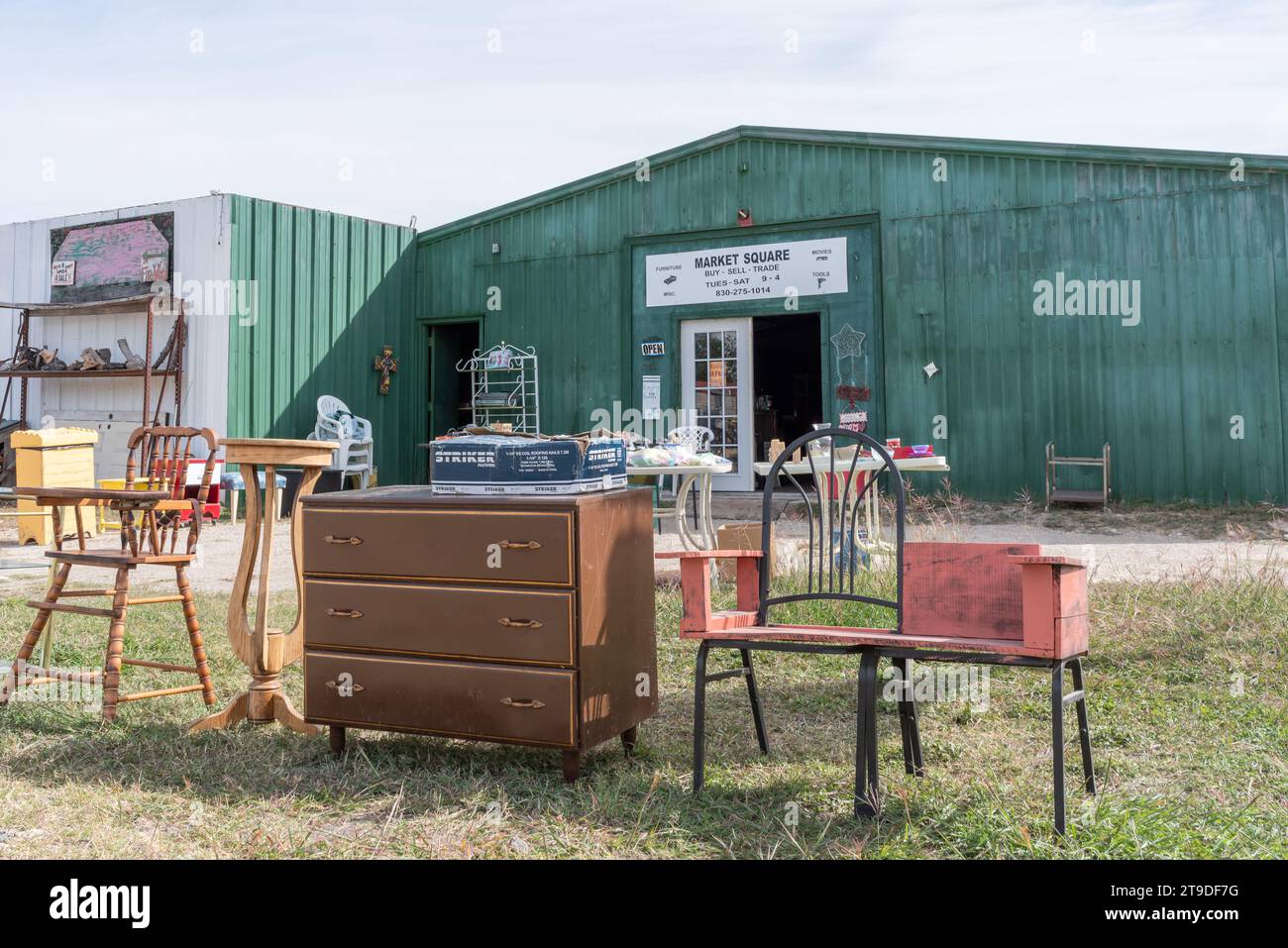 Exterior of secondhand store with sign on building that says Market Square, used furniture out