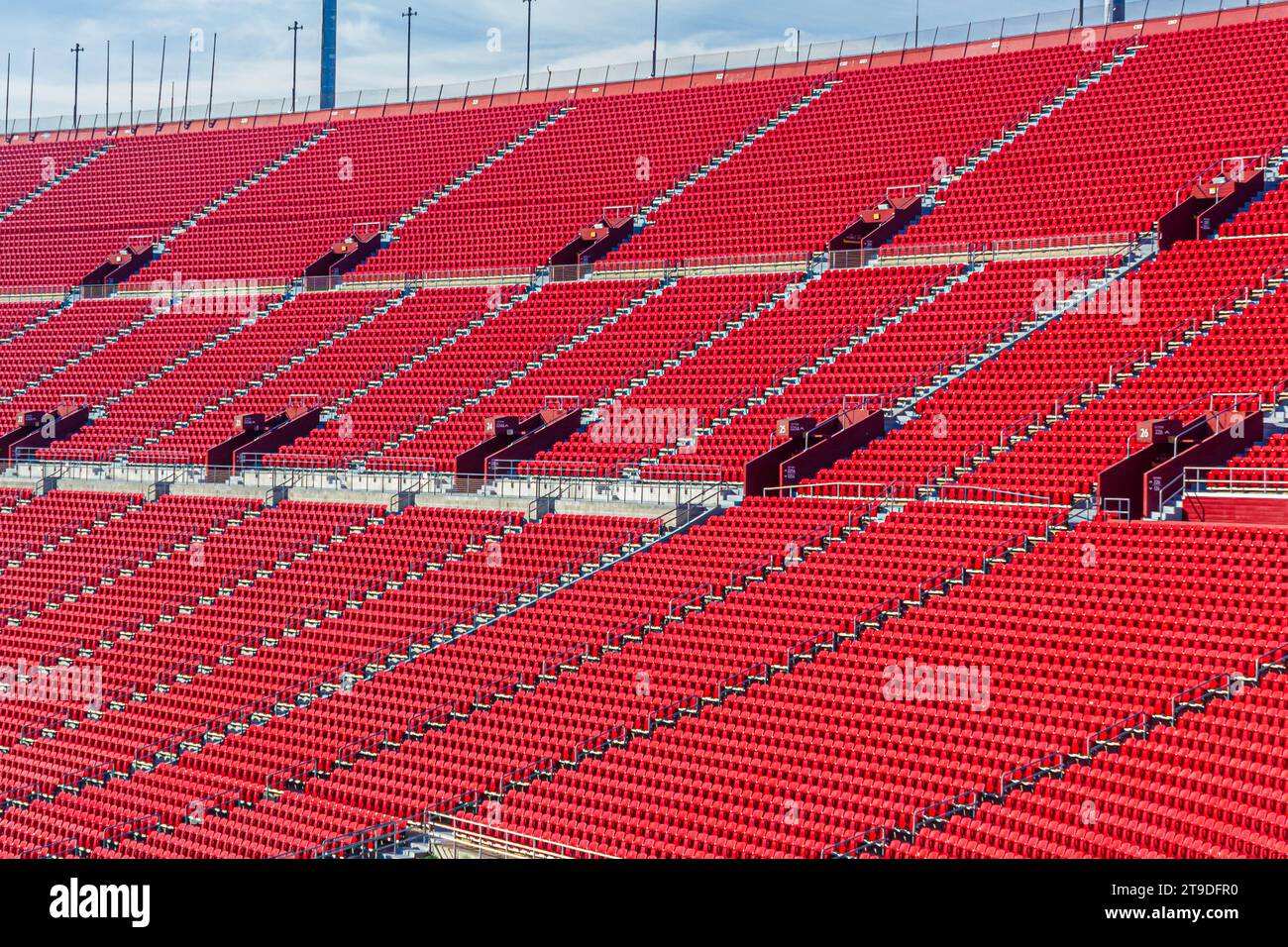 An athletic sports stadium on a sunny day with red seats Stock Photo