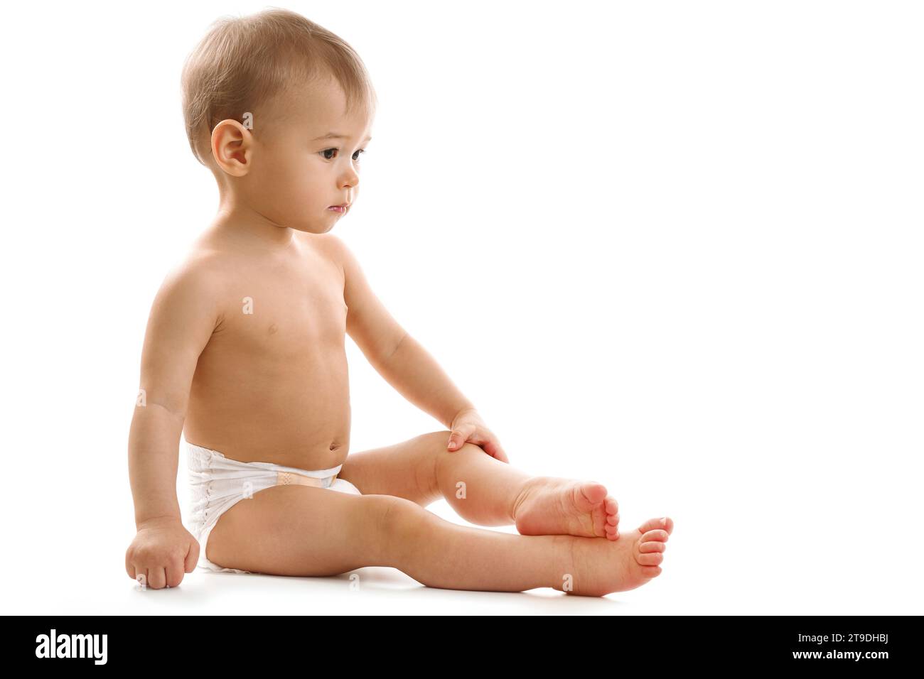 adorable-healthy-little-boy-in-diaper-is-sitting-and-looking-on-white