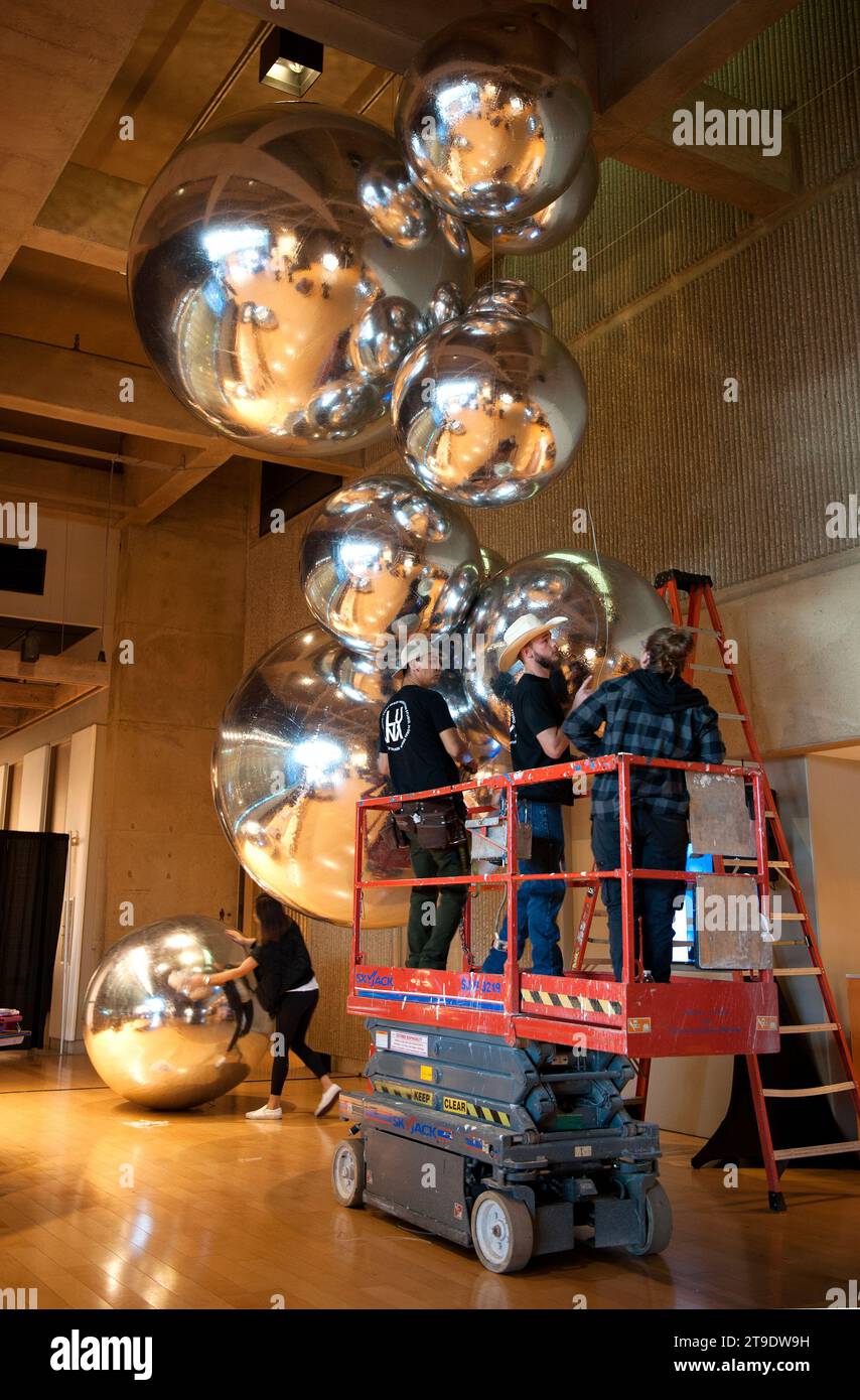 Event planners installing large balloons in the Palm Springs Art Musem for an exhibition opening, Palm Springs, California, USA Stock Photo
