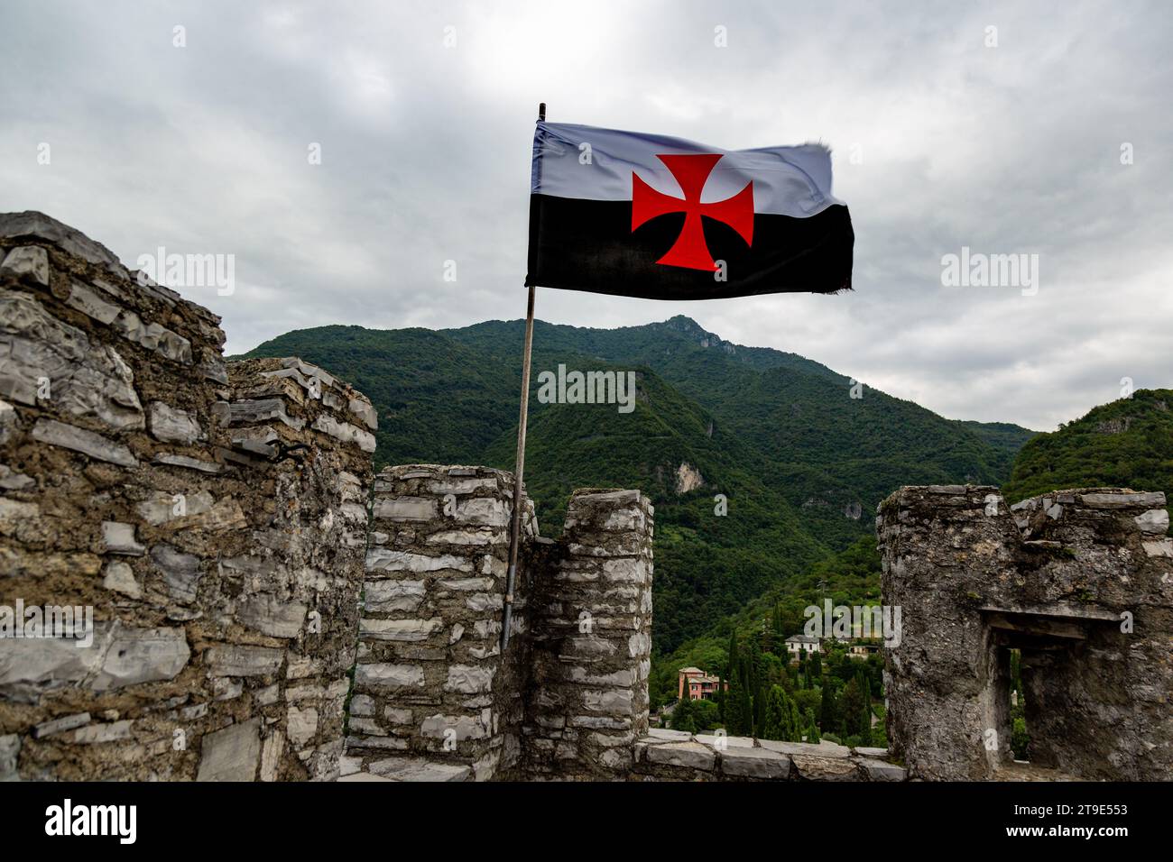 The flag of the Knights Templar flies upside down over Vezio Castle in Perledo, Lombardy, Italy. Stock Photo