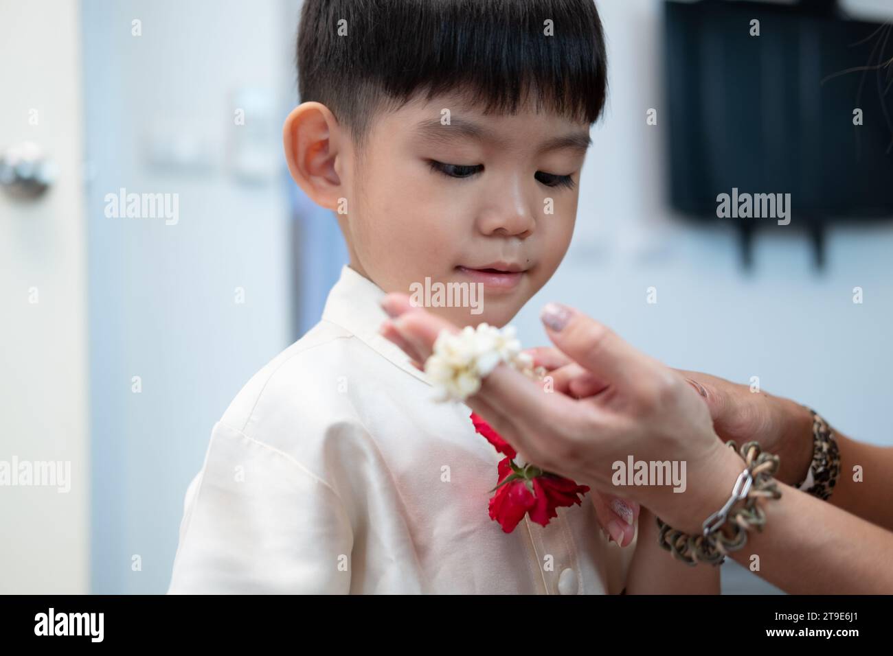 Little asian boy Giving a jasmine garland to mother On Thailand's National Mother's Day Stock Photo