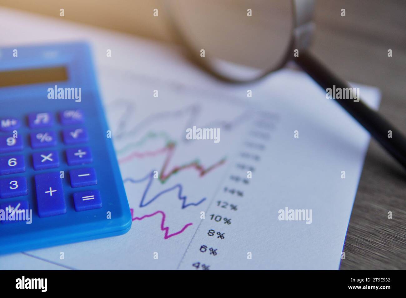 Closeup image of calculator, magnifying glass and line graph. Data and