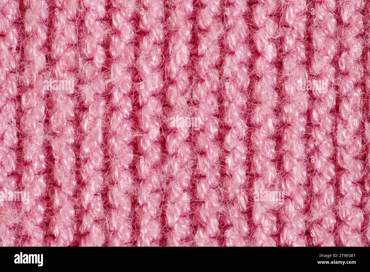 Knitted yarn made of pink wool threads, background structure, close-up macro view Stock Photo