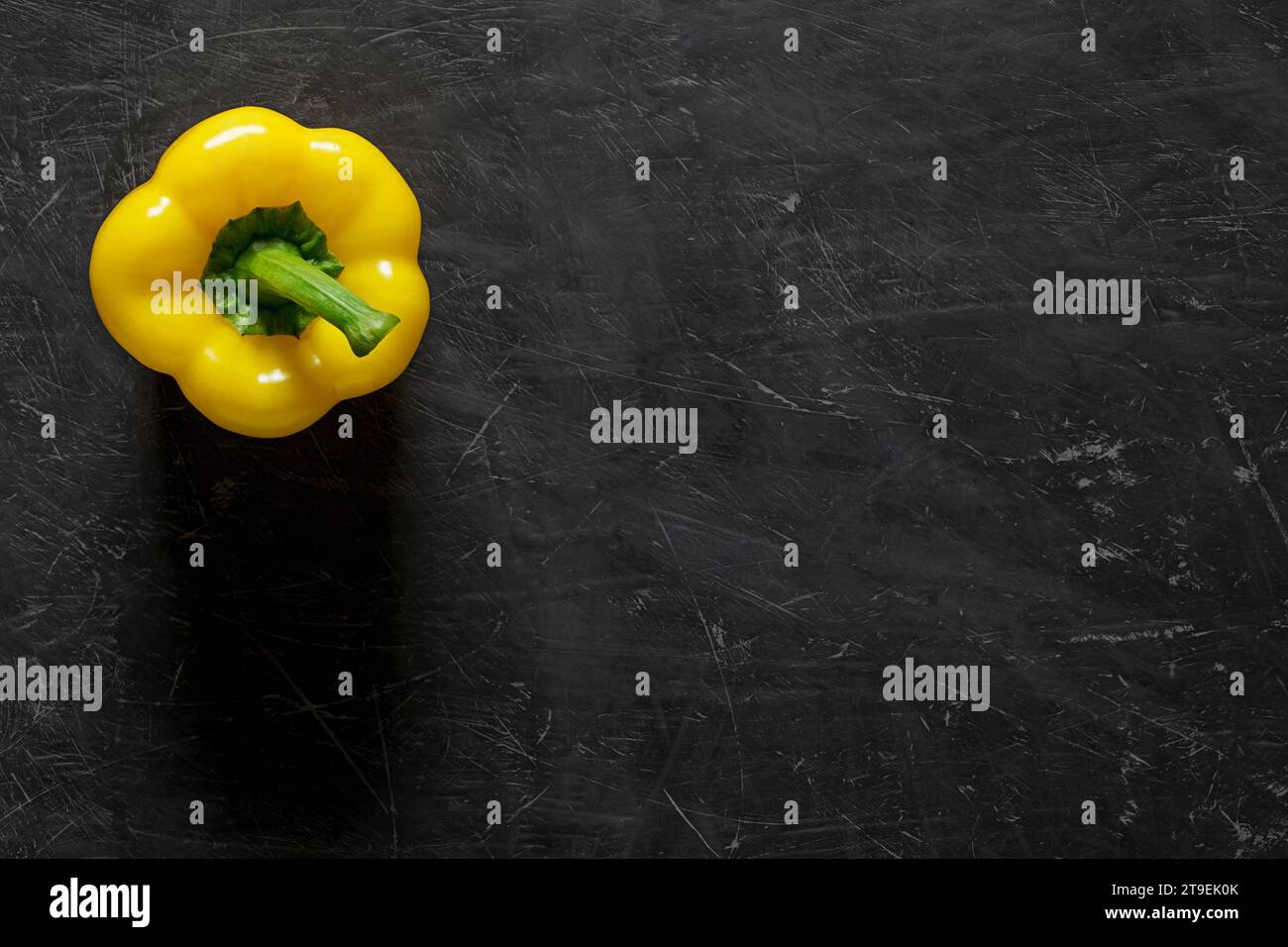 Sweet yellow Bulgarian pepper, whole one, top view dark background, with space to copy text. Stock Photo