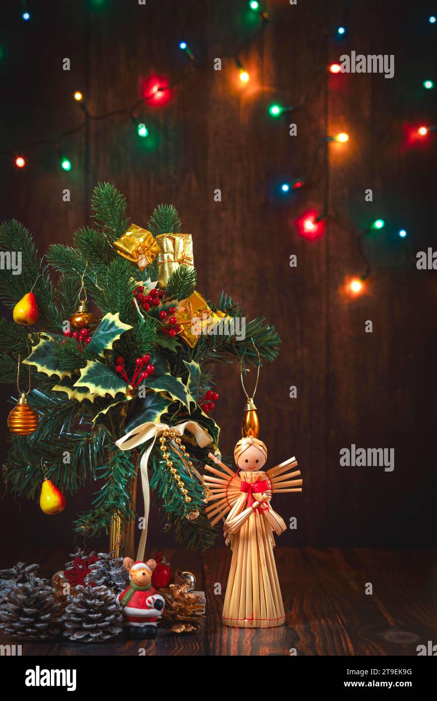 Christmas flower arrangement, decoration, fairy lights, straw angel, wooden background Stock Photo