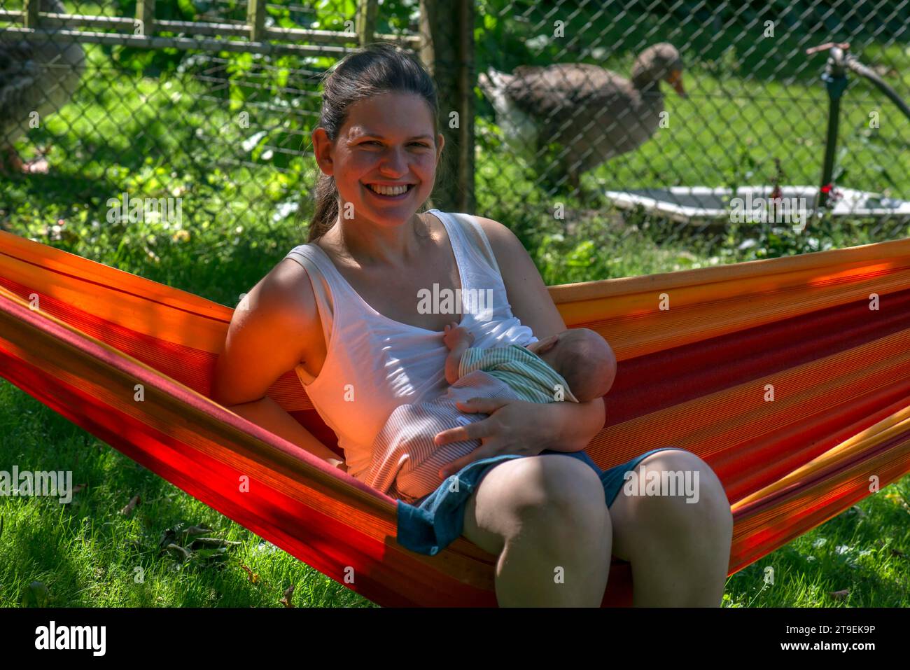 Young mother with baby in a hammock in the garden, Mecklenburg-Vorpommern, Germany Stock Photo