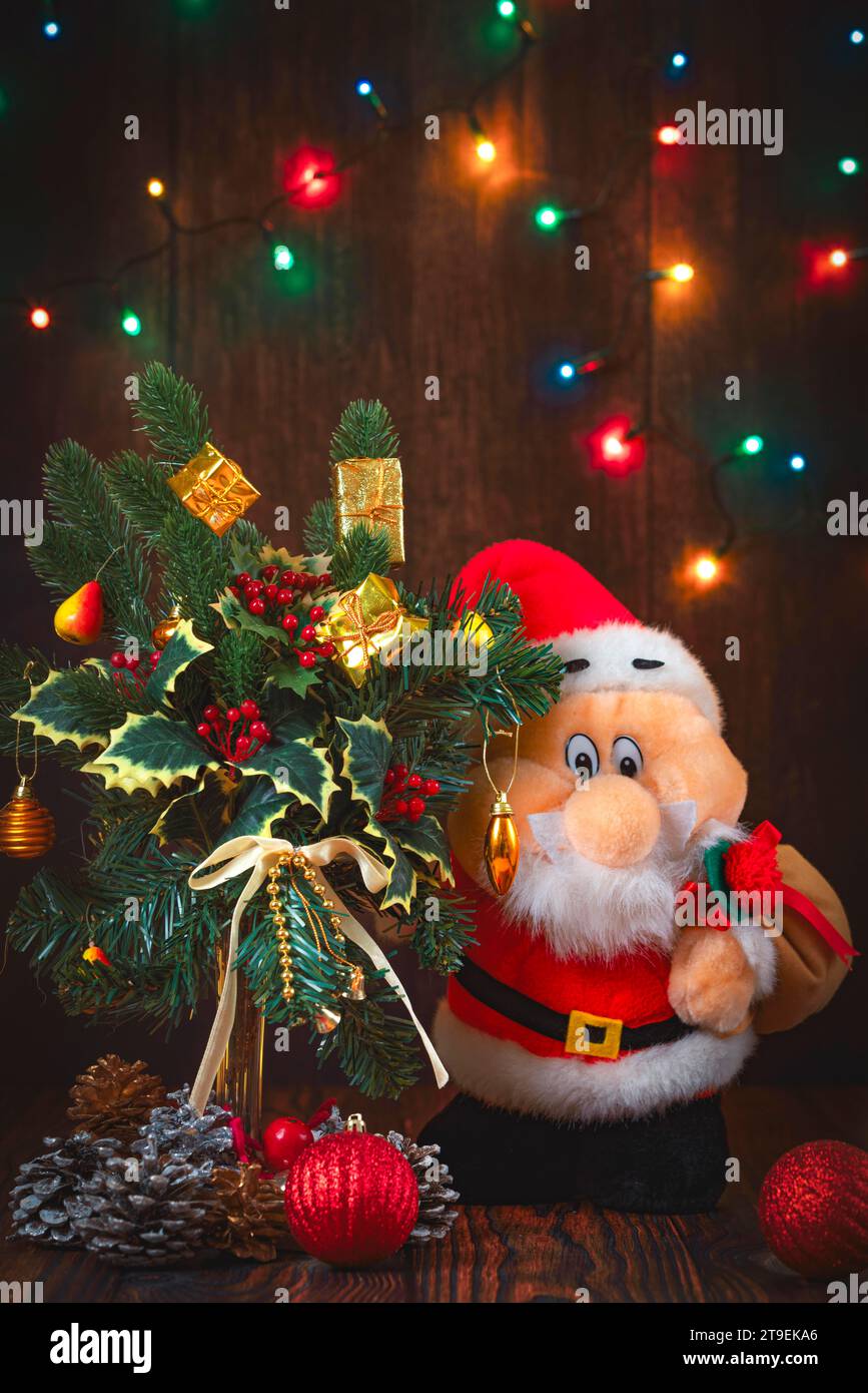 Christmas flower arrangement, decoration, fairy lights, Father Christmas, wooden background Stock Photo