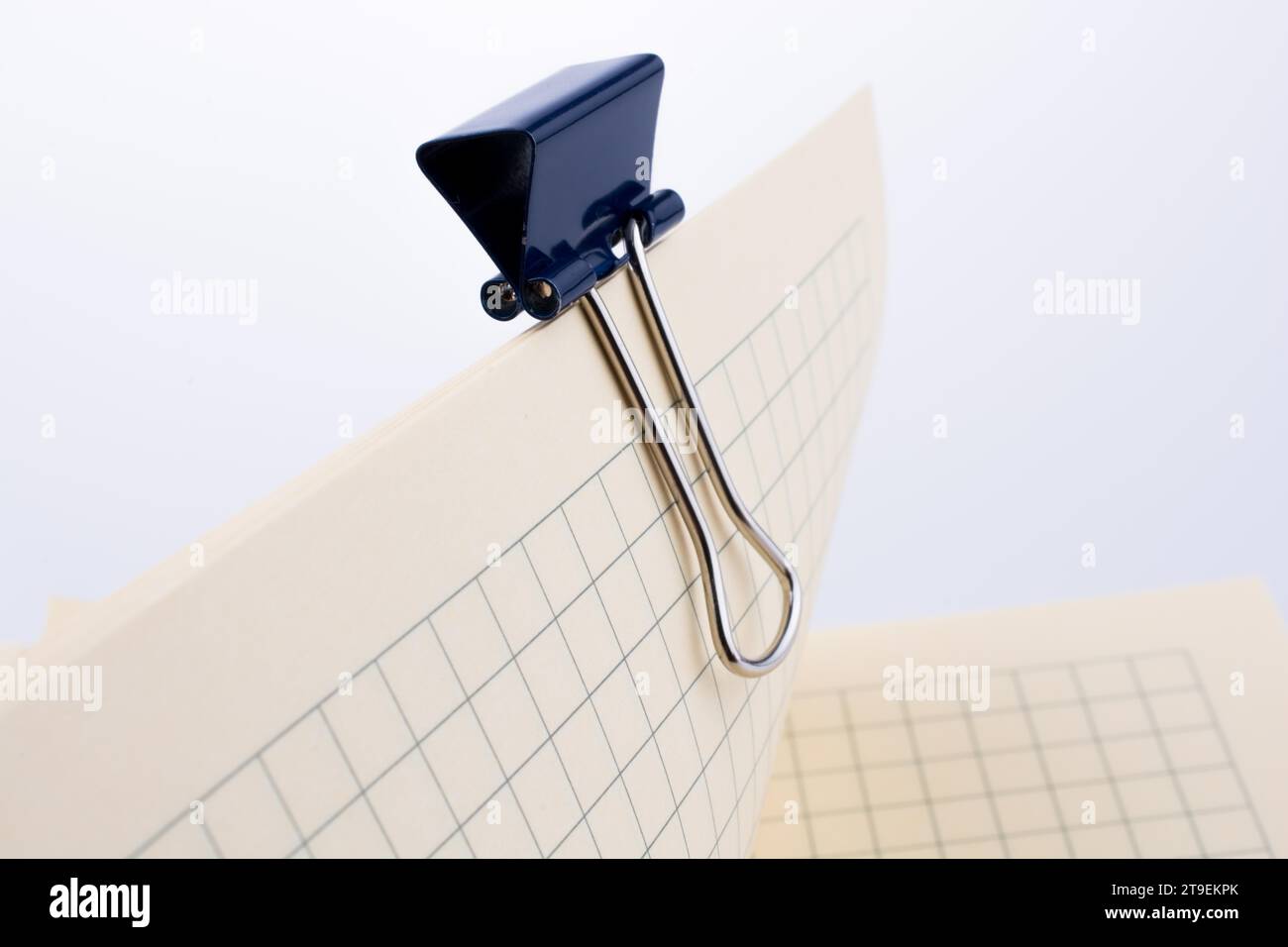 Colored paper clip on a checked notebook page Stock Photo