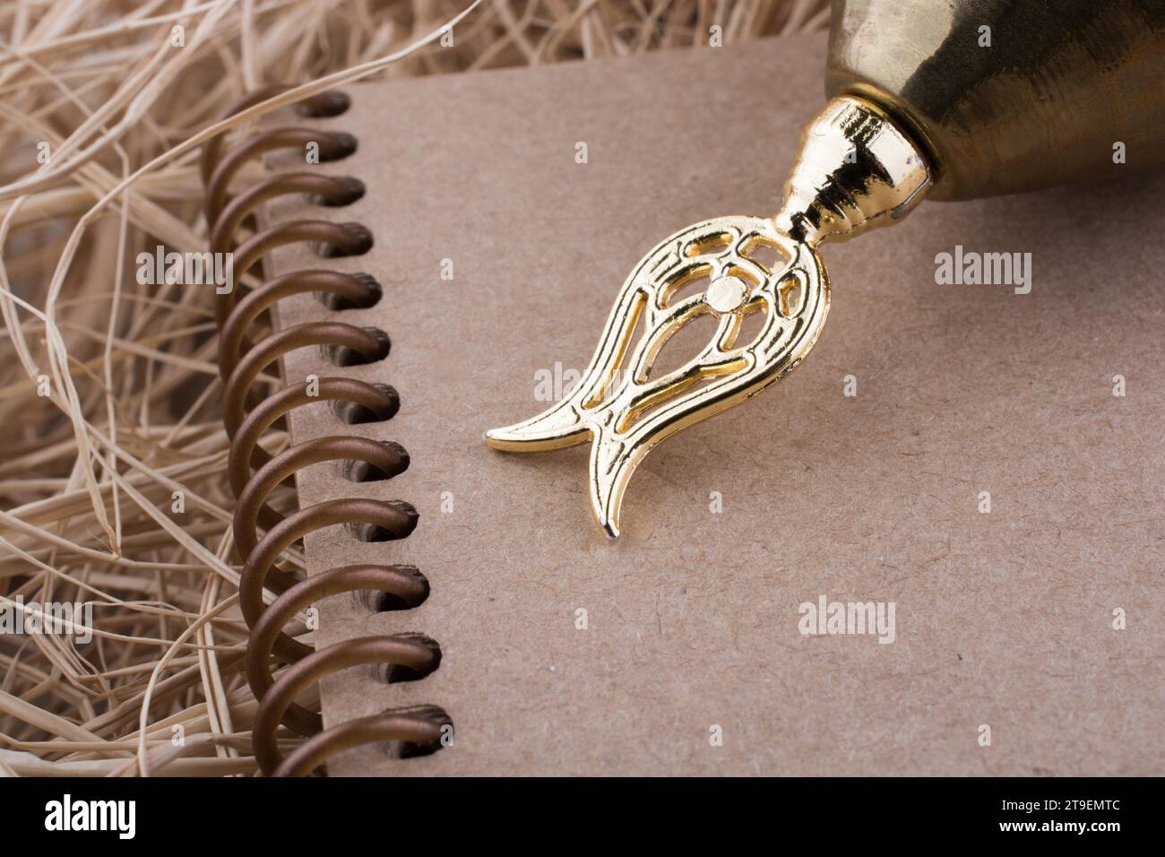 Spiral notebook placed on a straw background Stock Photo - Alamy