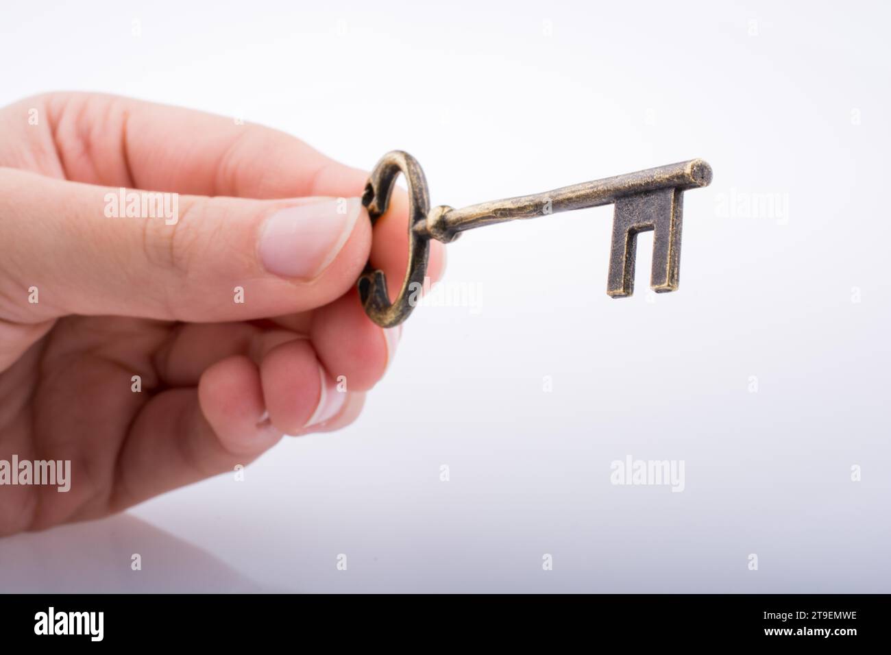Hand holding a key on a white background Stock Photo - Alamy