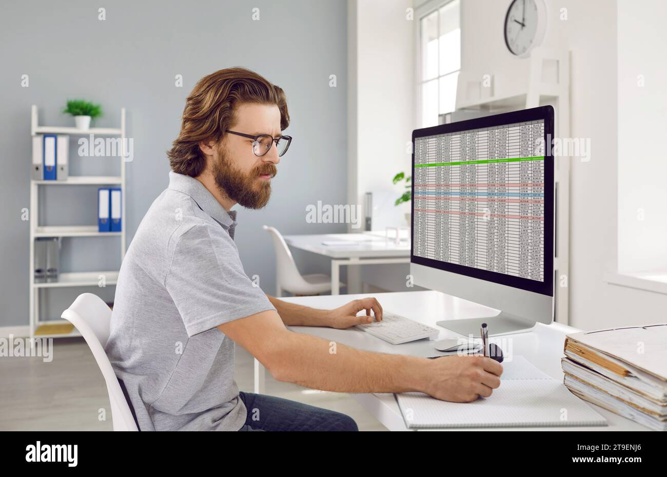 Focused businessman working on spreadsheet on computer in office. Stock Photo
