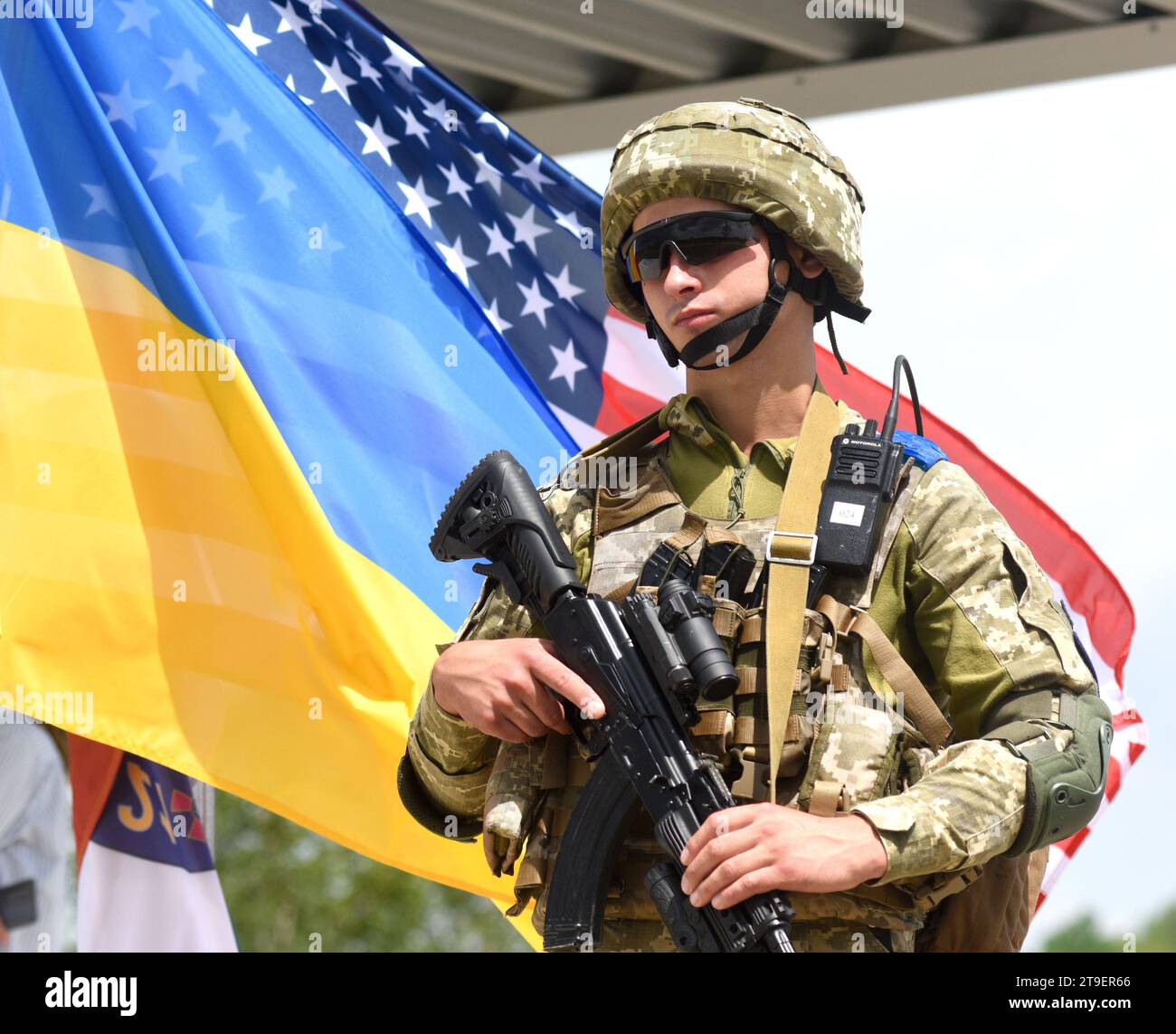 Yavoriv, Ukraine - July 27, 2021. Ukrainian soldier near  flags of Ukraine and US during the Three Swords 2021 multinational military exercise near Ya Stock Photo