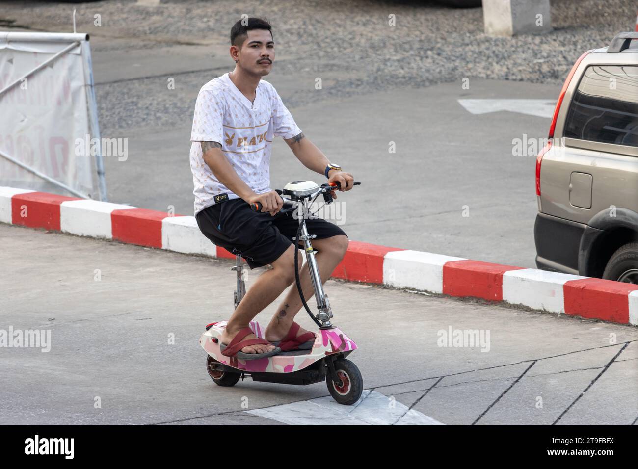 SAMUT PRAKAN, THAILAND, NOV 03 2023, A young man rides an electric scooter Stock Photo