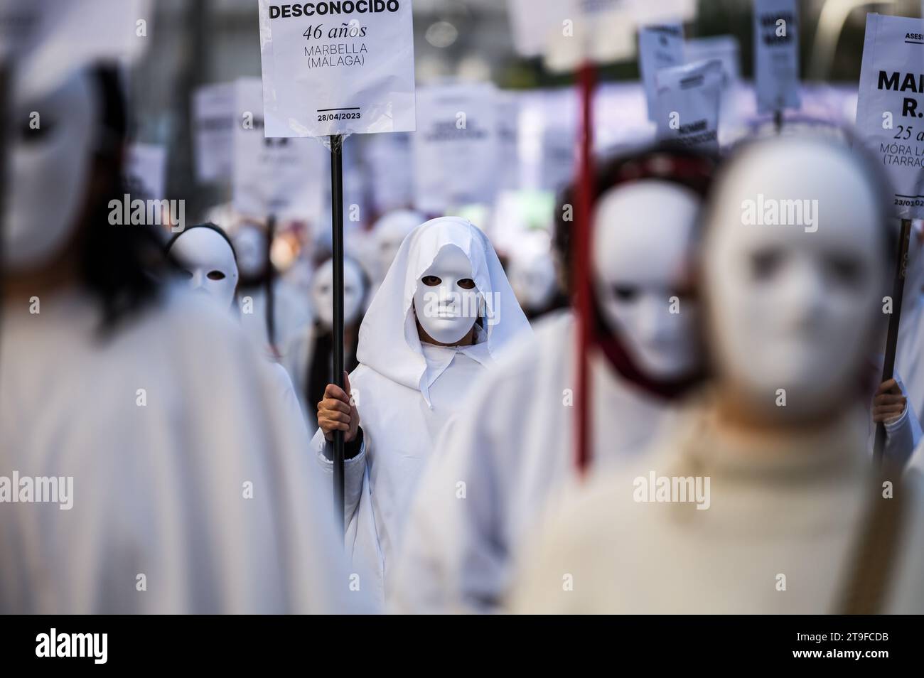 Madrid, Spain. 25th Nov, 2023. Women wearing white masks and carrying signs with the names of murdered women this year by male violence are seen during a demonstration for the International Day for the Elimination of Violence against Women. Credit: Marcos del Mazo/Alamy Live News Stock Photo