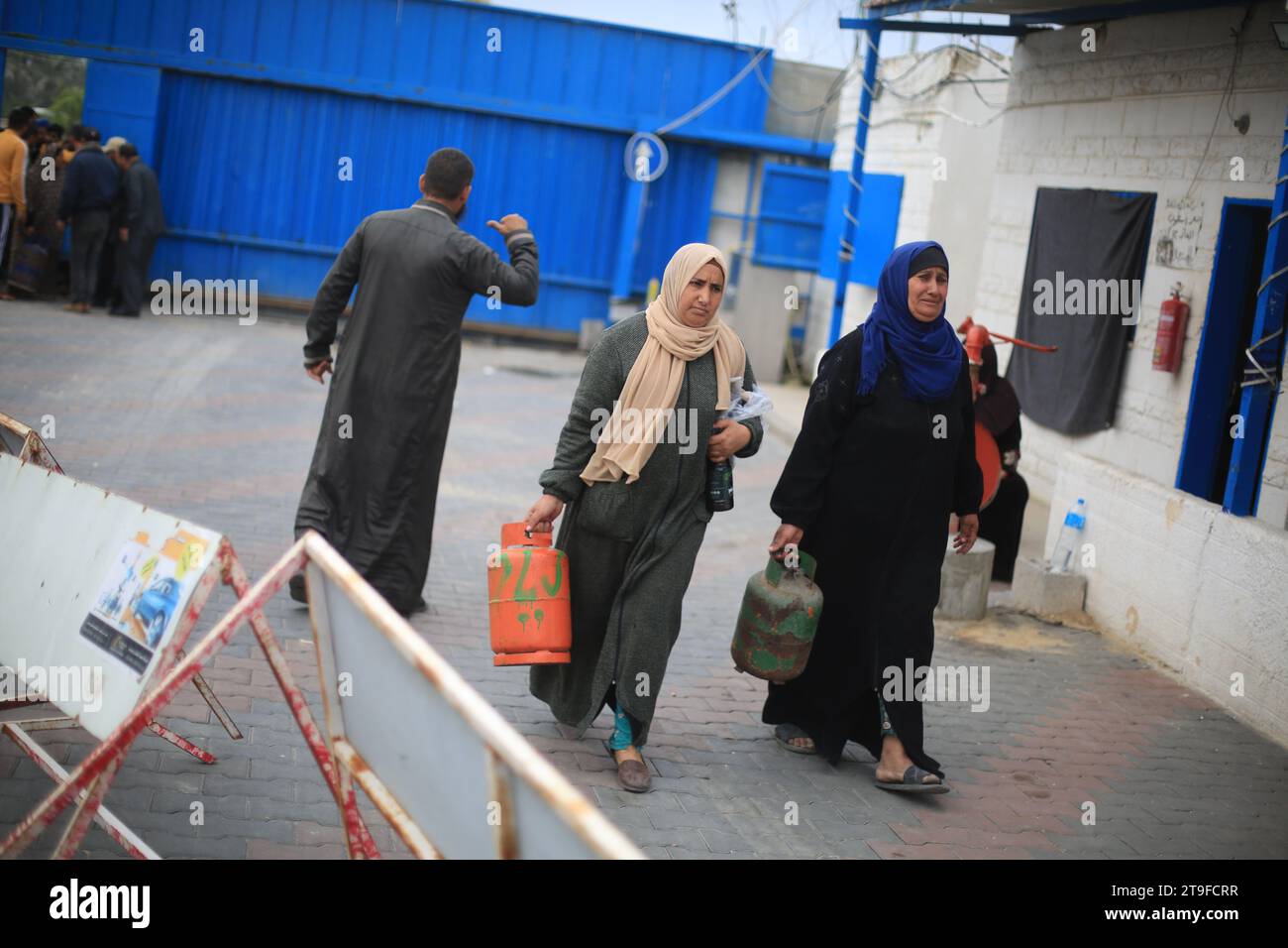 Khan Yunis, Palestinian Territories. 25th Nov, 2023. Palestinians carry their liquid gas cylinders after refilling them, on the second day of a four-day cease fire between Israel and the Palestinian militant group Hamas. Credit: Mohammed Talatene/dpa/Alamy Live News Stock Photo