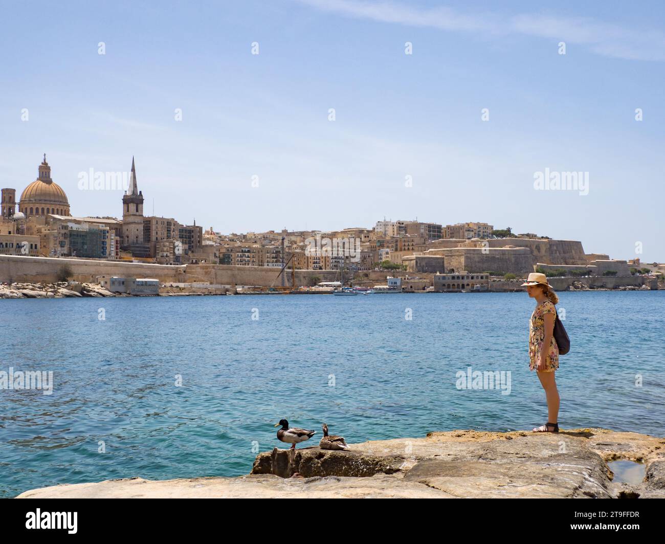 Tourist on the a rocky coast with coves and turquoise waters in Malta. Europe Sliema coastline in Malta, Europe. Stock Photo