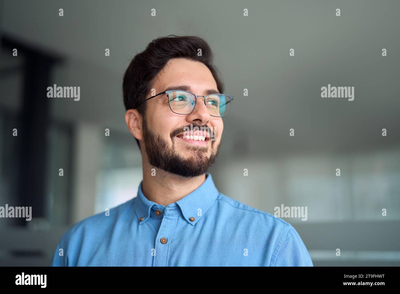 Happy young latin business man leader wearing glasses looking away. Stock Photo